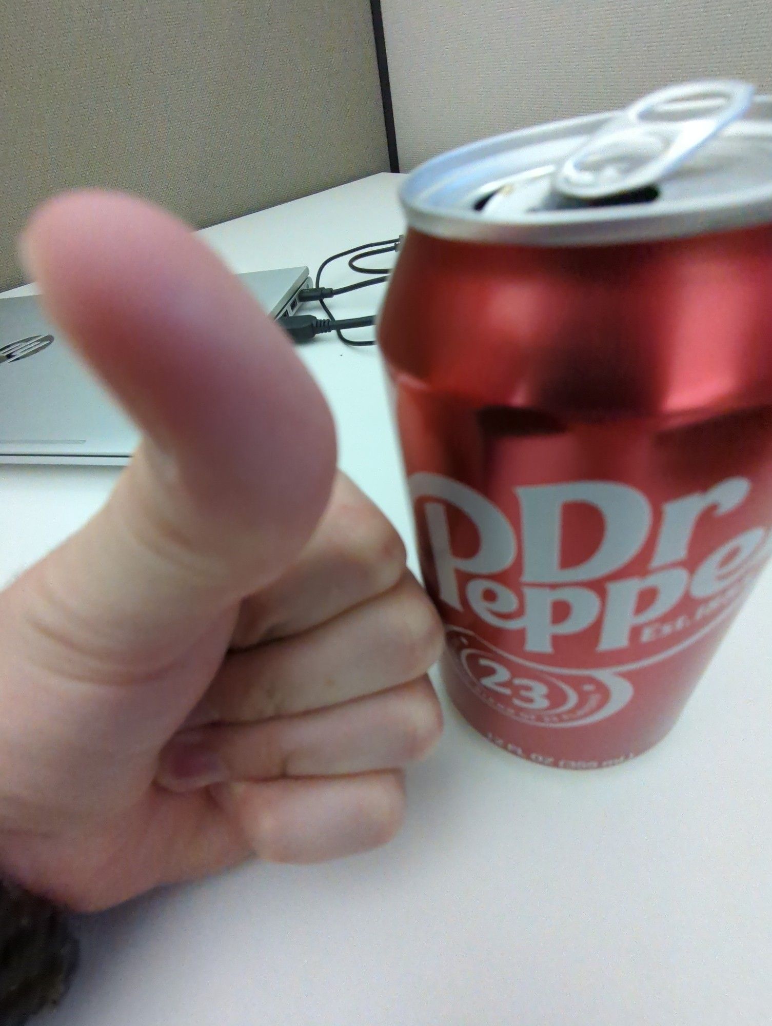 Me giving a thumbs up next to a Dr. Pepper but tilting my thumb towards the camera lens, making it look weird