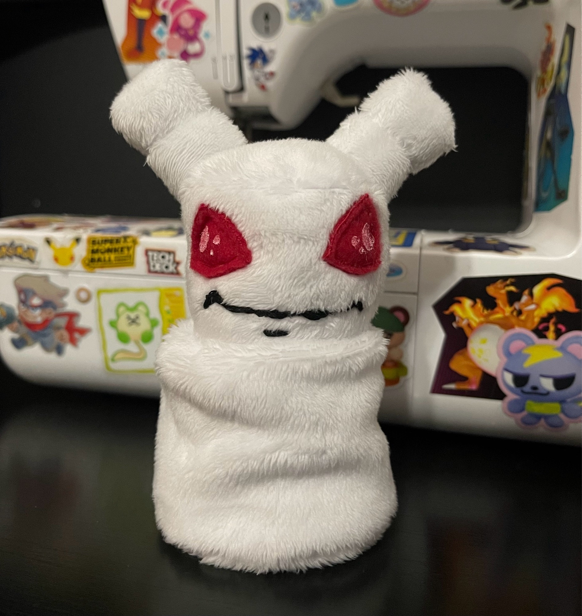 Small plush of the Neopet Mallow Grundo, which Grundo is a little alien neopet with two antennae and big red alien eyes, and the Mallow variant is a Grundo made of marshmallows with mallow antennae, but no arms or legs.  It’s kind of like a snowman, but the pieces are marshmallows and not balls of snow