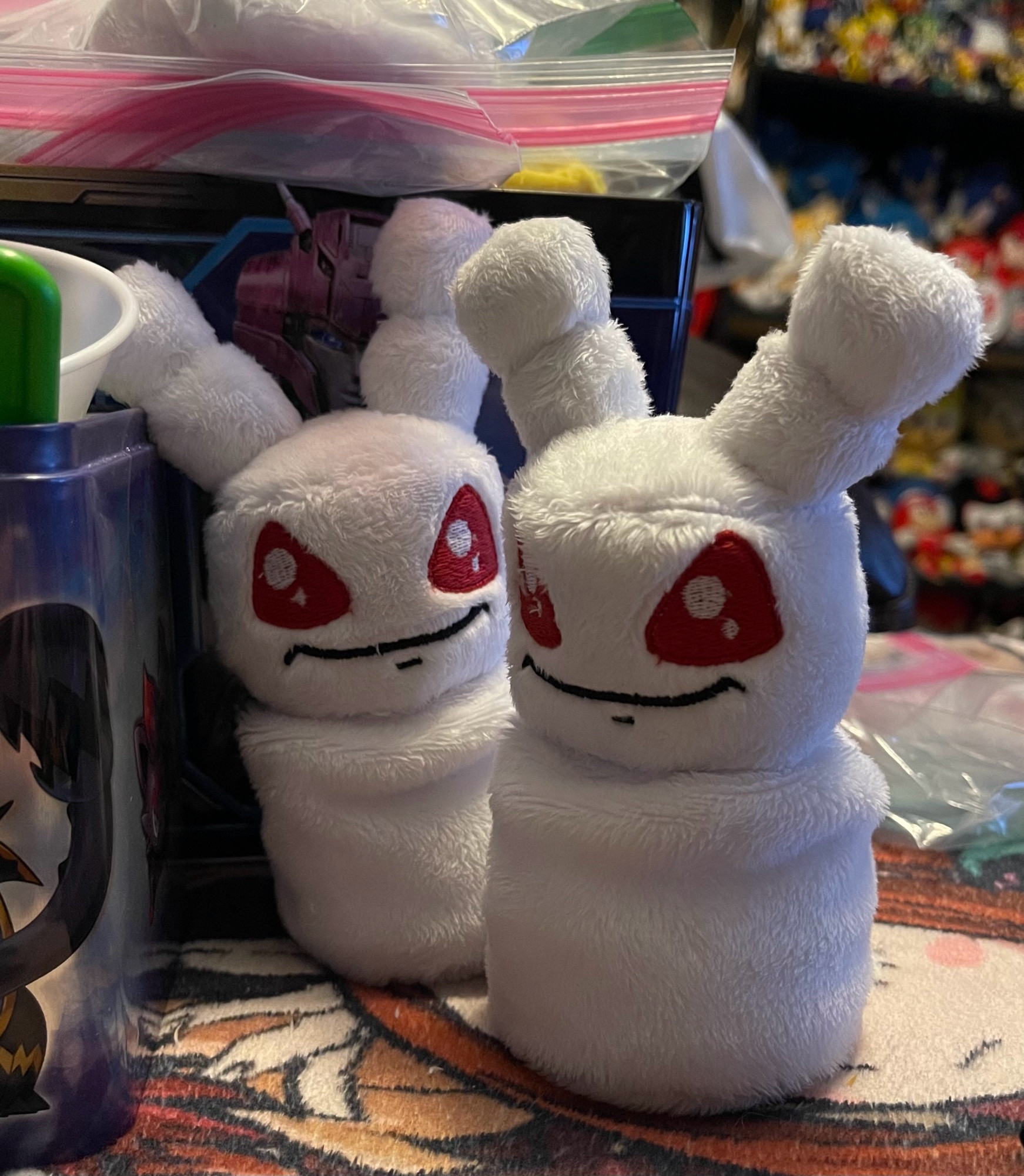 handmade plush of two Mallow Grundo from Neopets, which are little white aliens with red eyes with bodies made of marshmallows similar to how a snowman is built