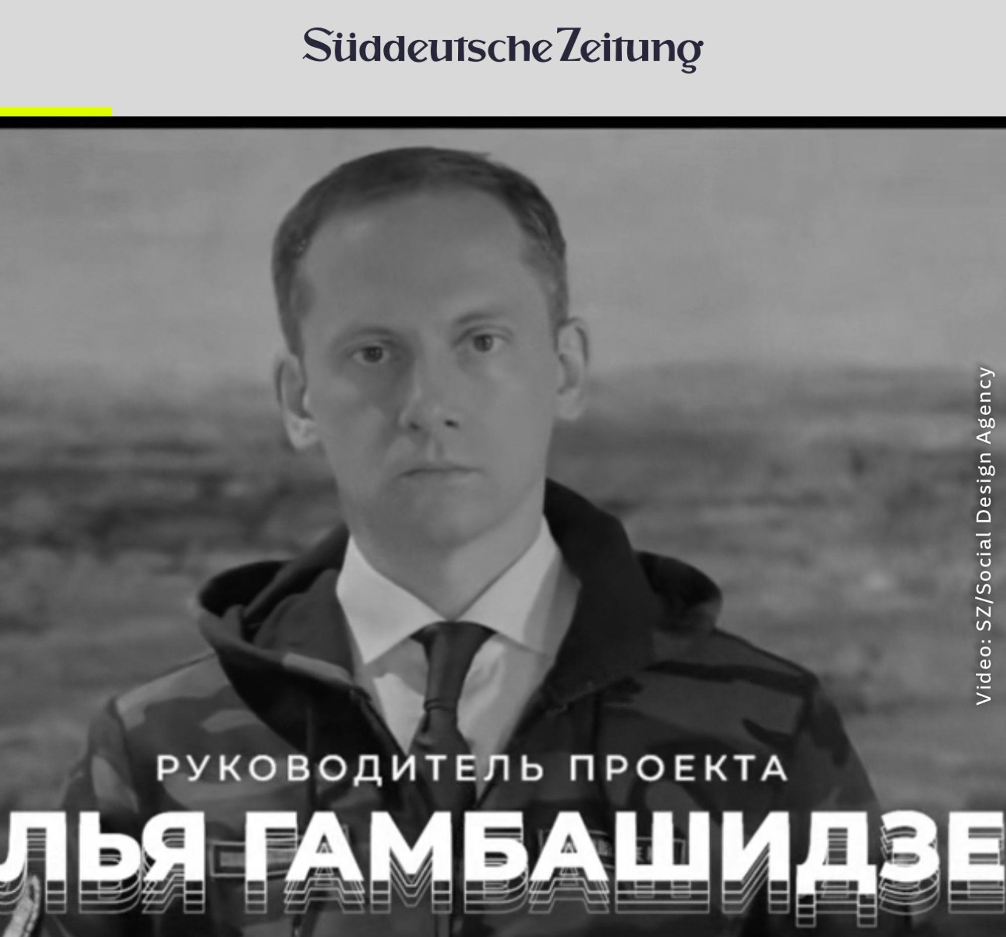 Zu sehen ist ein Mann in einer Flecktarn-Kapuzenjacke, am Ärmel die russische Flagge und ein buntes Abzeichen mit dem Schriftzug „Ideologische Streitkräfte Russlands“. Er wird Ilja Gambaschidse genannt, wahlweise ist er „Kommandeur einer Spezialeinheit“ (Uniform-Aufnäher) oder „Projektleiter“ (eingeblendete Schrifttafel).