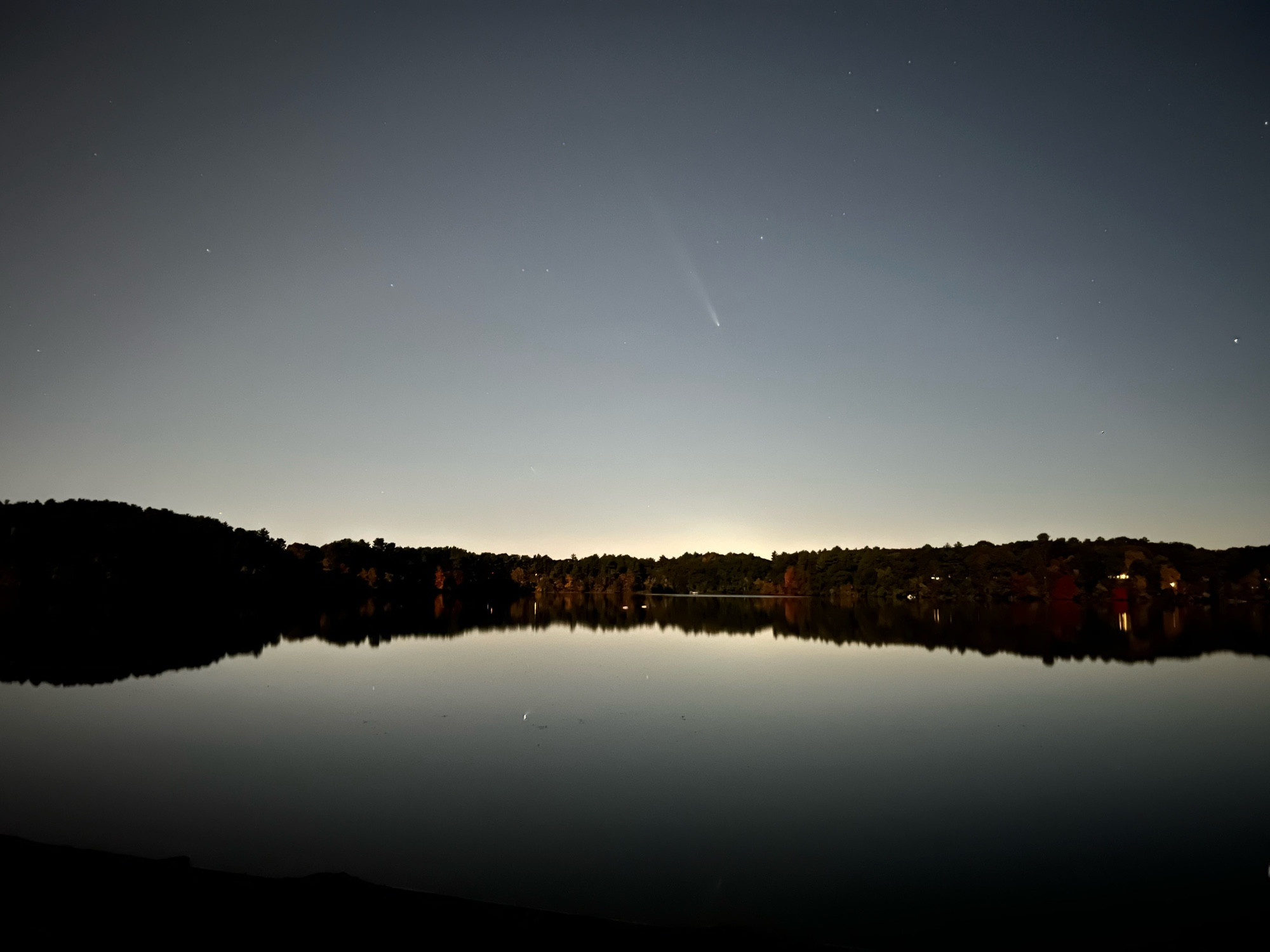 photo taken on the beach of a lake. dark, an hour after sunset about.  in the center of the picture, very faint, is a comet