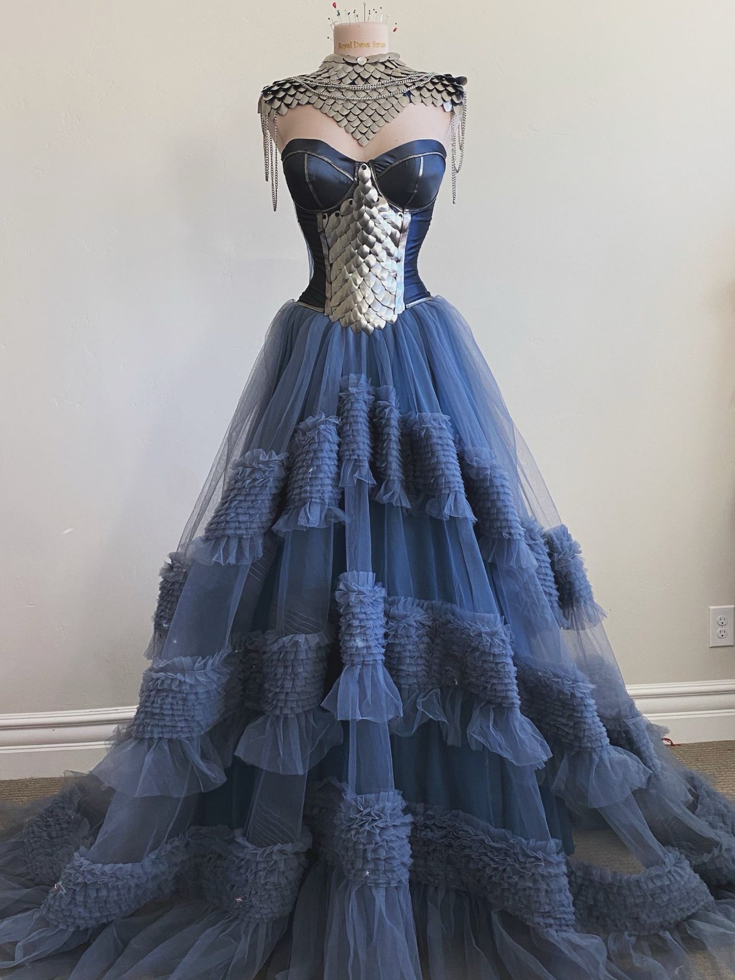 Blue strapless ballgown with a metal scale piece on the abdomen and matching metal scale shoulder/neck piece and fluffy tulle skirt