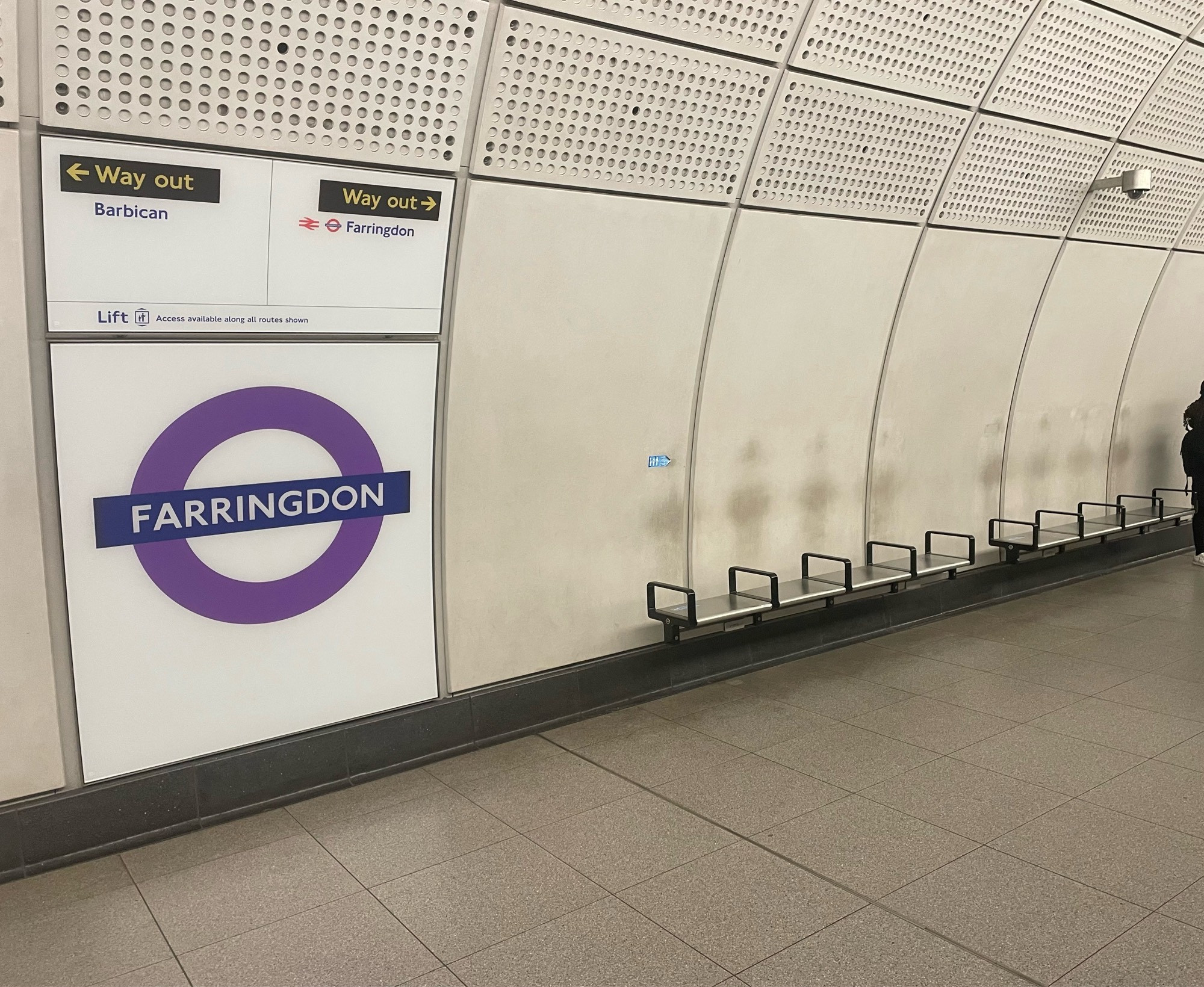 Outlines of passengers impressed against the wall of Farringdon Station.