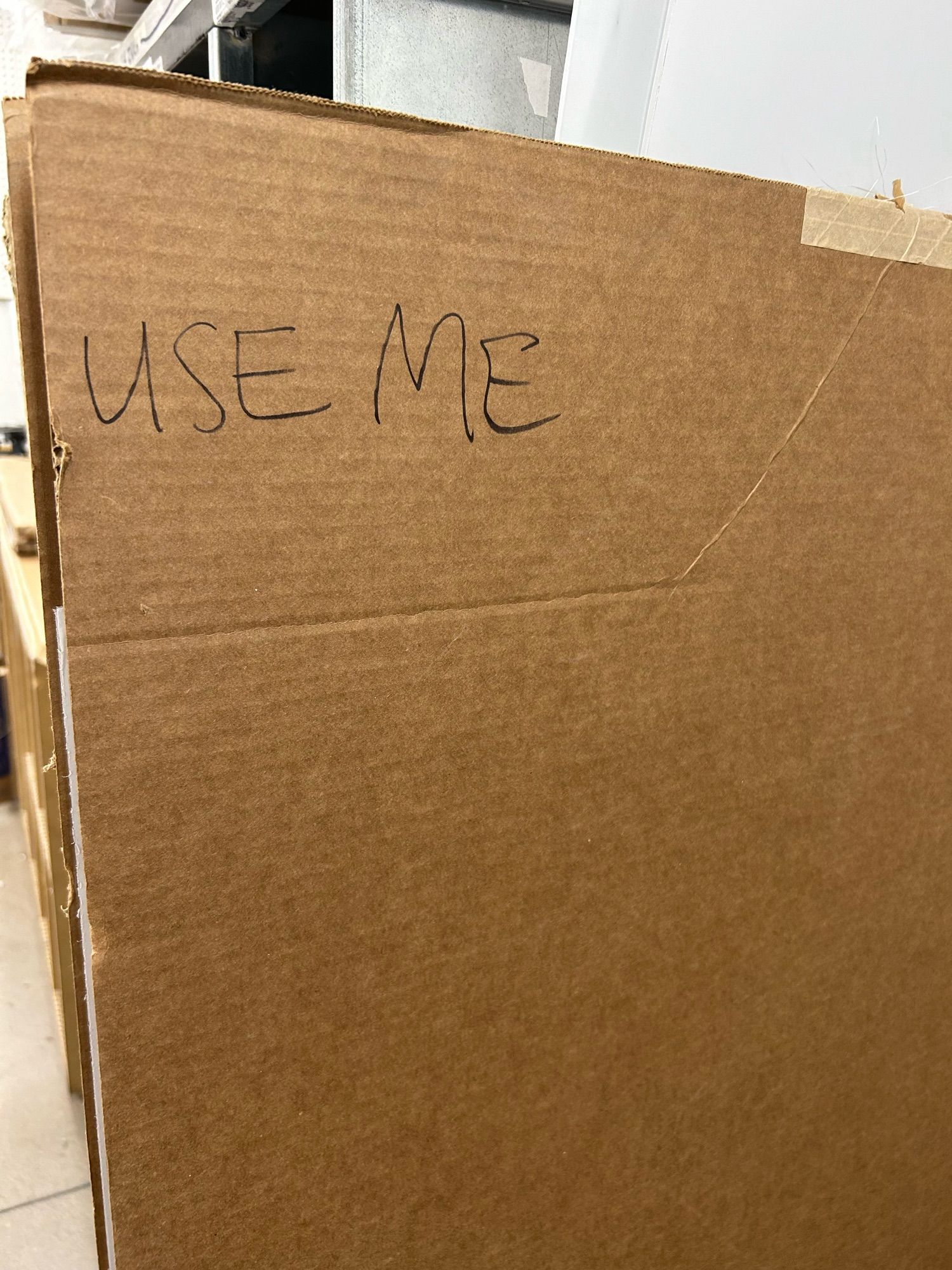 a large piece of cardboard with “use me” written on it in sharpie