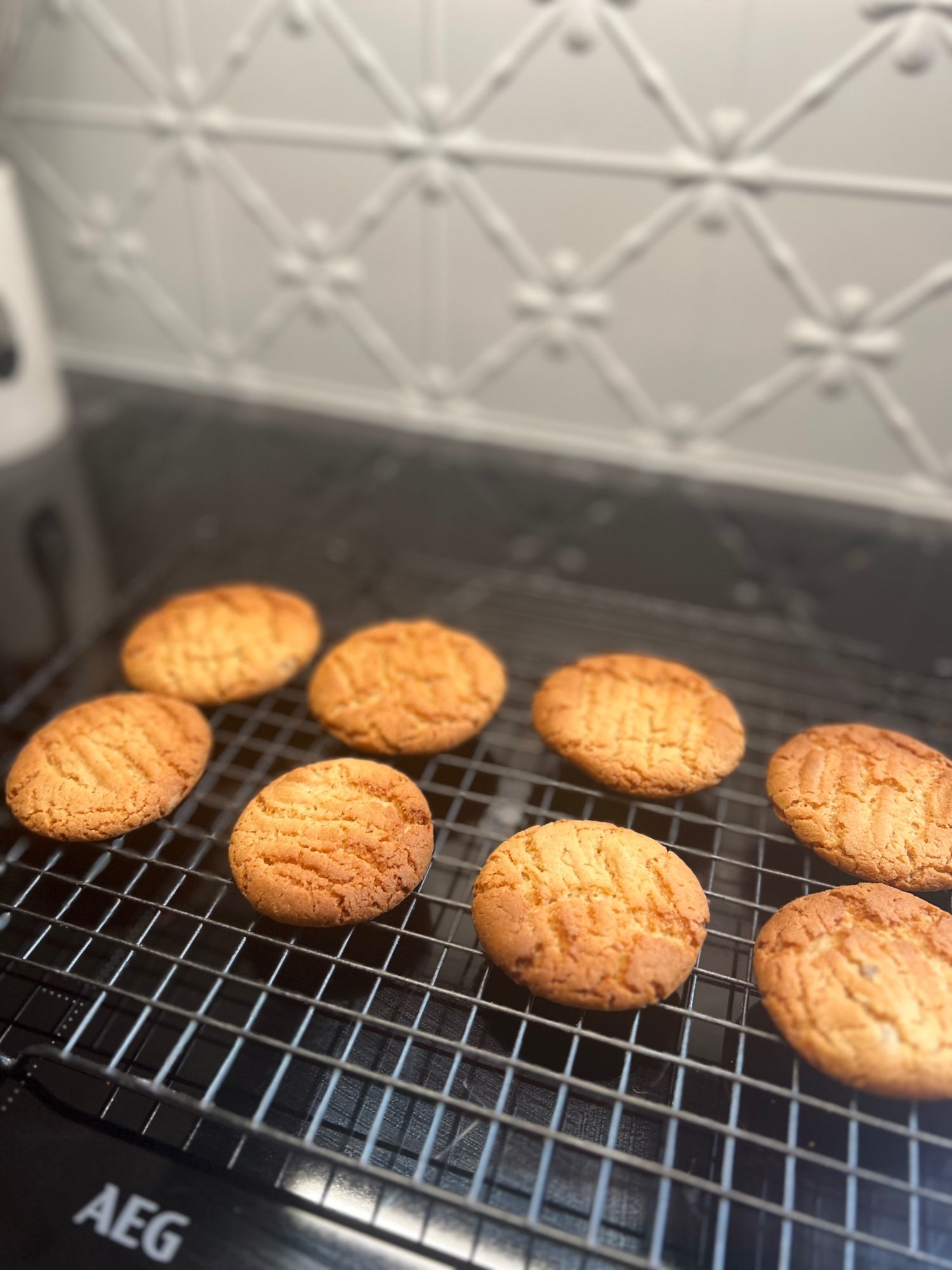 8 ginger biscuits on a wire tray, looking like they've just come out of the oven