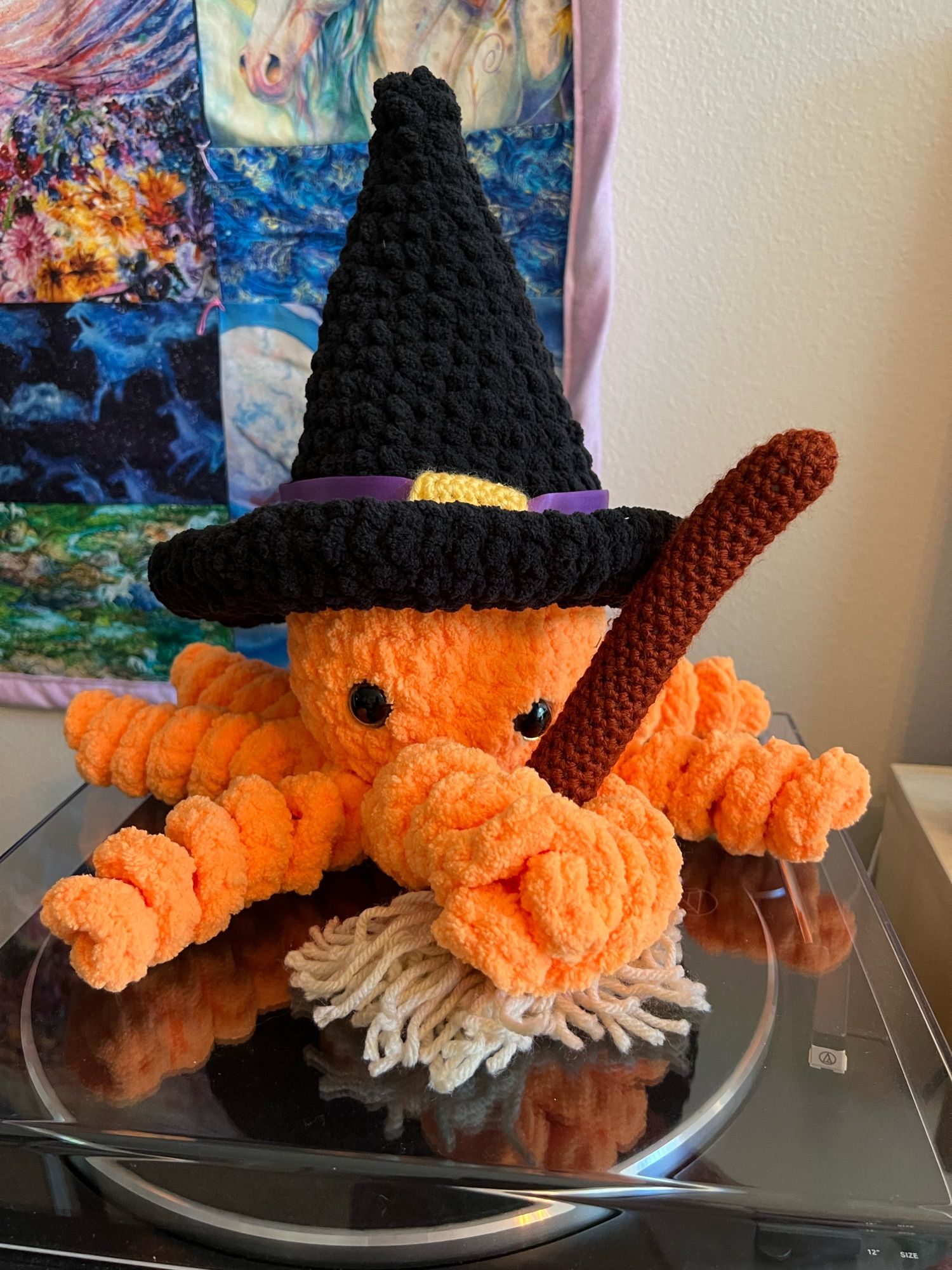 Crocheted octopus with witch hat and broomstick