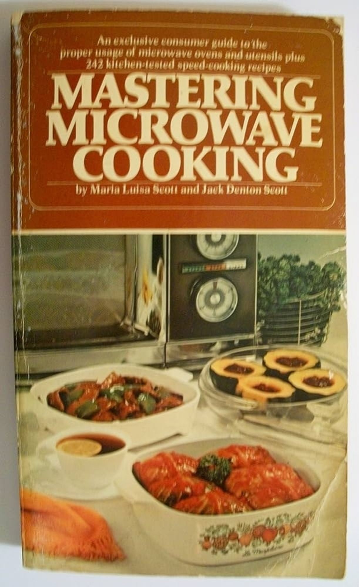 Cover of an old book MASTERING MICROWAVE  COOKING. Some heinous looking foods (pale squash, red and brown loops and solids). This is not the way of the microwave. It is for reheating goops made using conventional means, not first-round cooking.