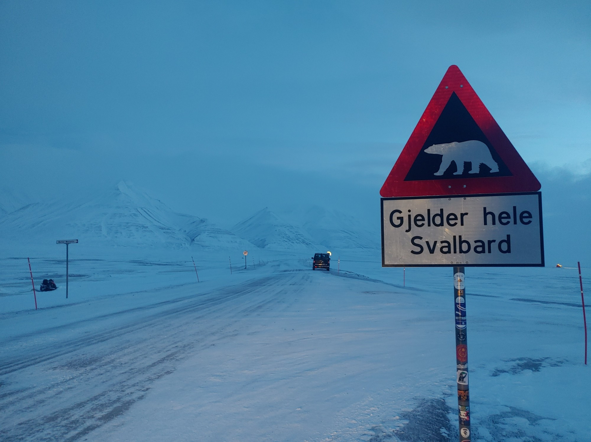 The famous "careful, polar bears" road sign with snowy mountains in the background