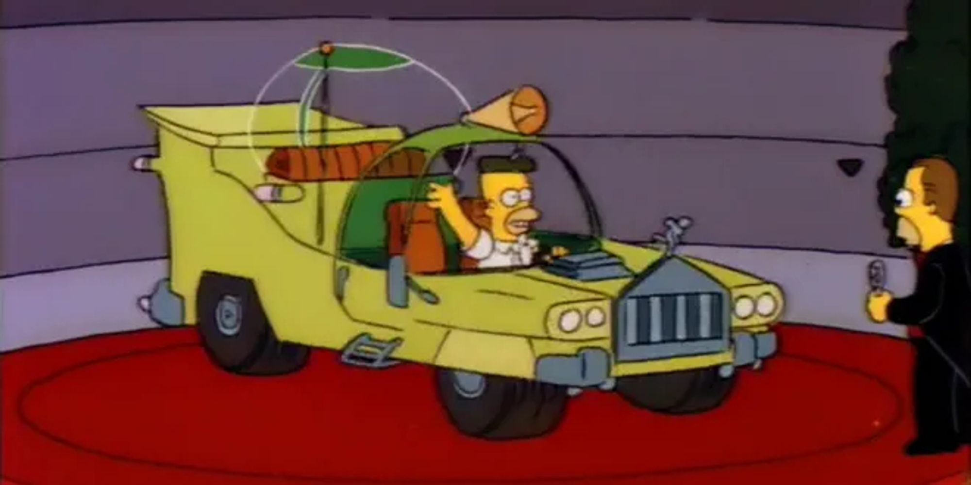 Ein screenshot von den Simpsons, er zeigt Homer in seinem selbst entworfenen Auto. Das Auto ist giftgrün, unsagbar hässlich und unpraktisch mit allerlei überflüssigem Gedöhns.