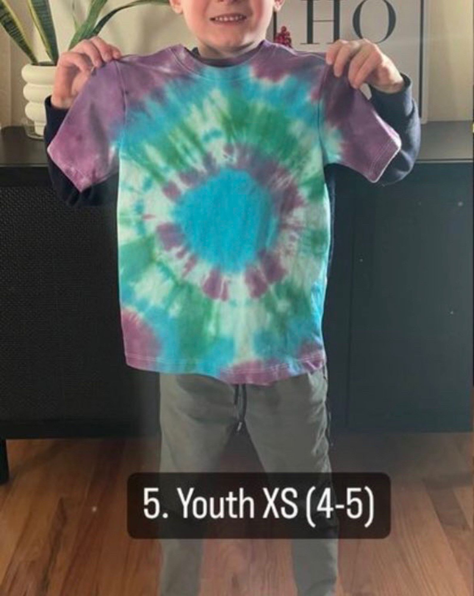 Kid showing off tie dye shirt