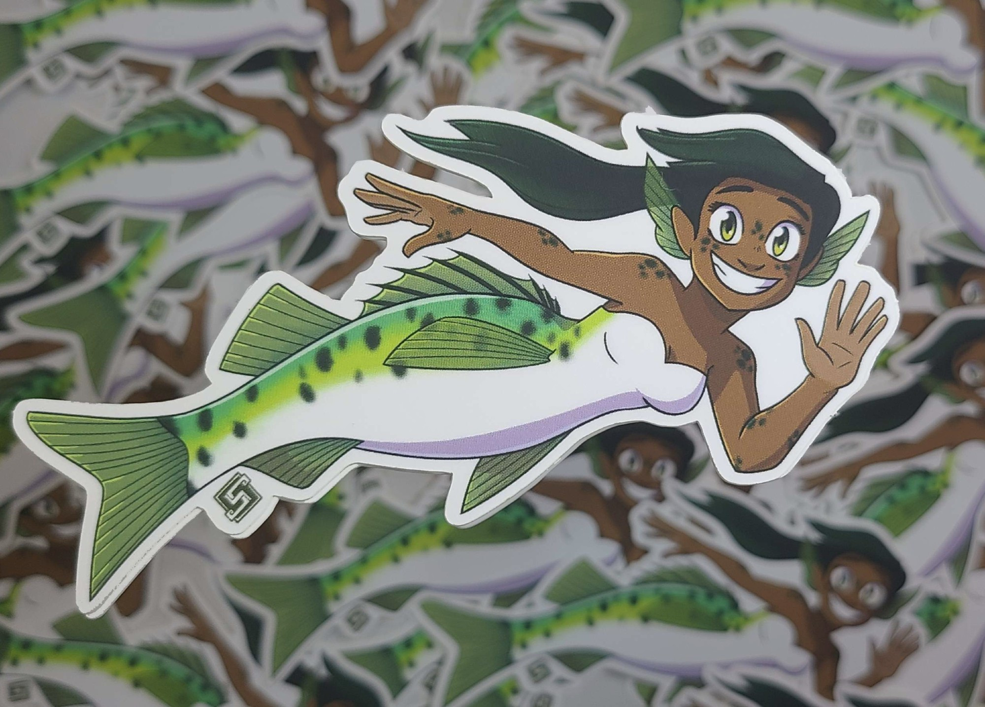 A sticker of a Japanese sea bass mermaid. She is specifically based on the species of sea bass in Animal Crossing. She's smiling towards the viewer and waving happily.