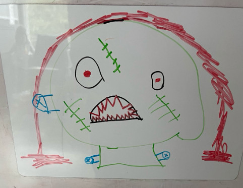 An image of a monster, with sharp teeth, scars, bolts, and blood pouring from a hole in their head - as drawn by a 6yo.