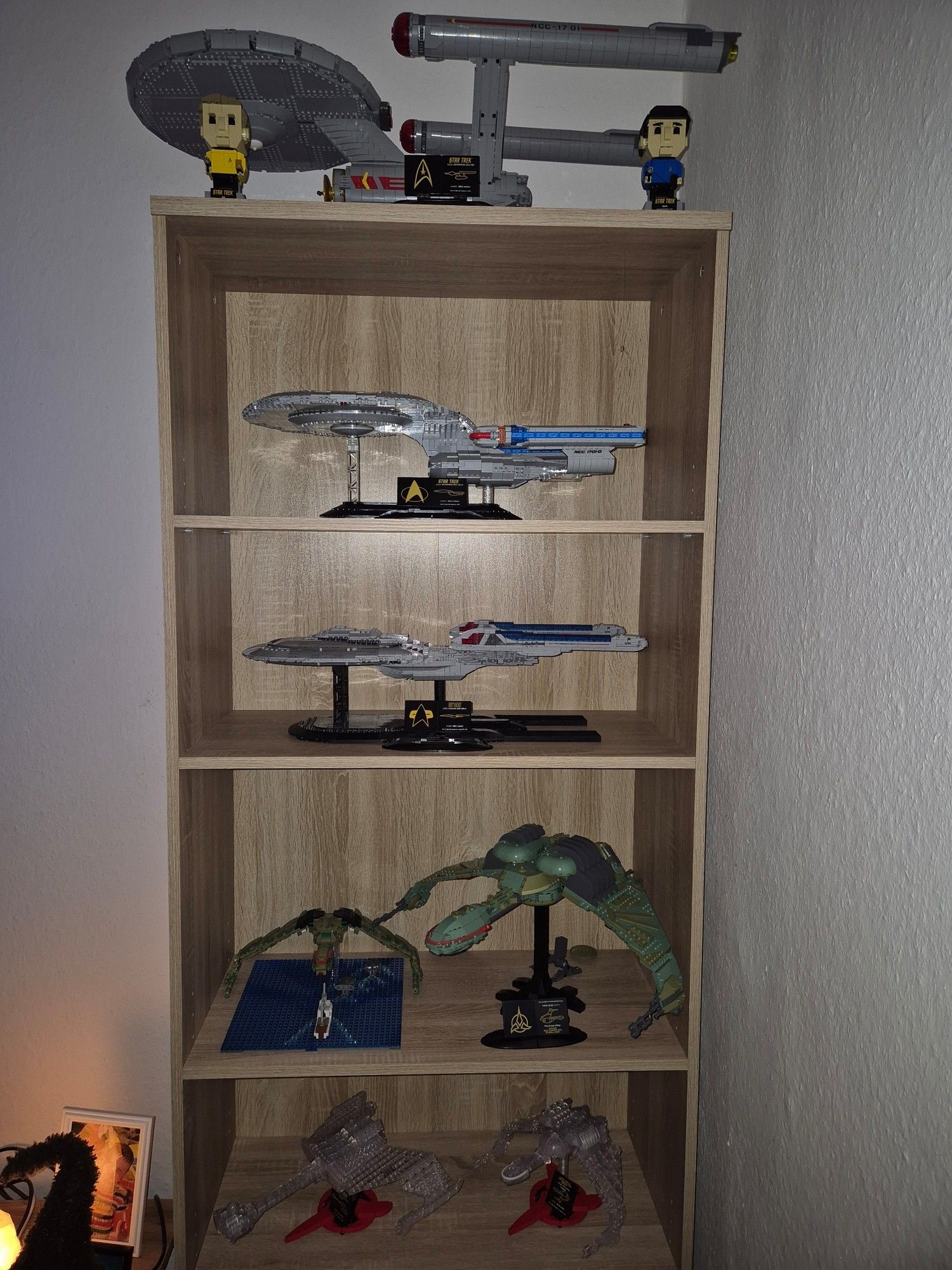 Regal mit Klemmbausteinsets von BlueBrixx

Von oben nach unten stehen auf dem Regal 

Enterpise NCC-1701
Enterprise NCC-1701-D
Enterprise NCC-1701-E
links Bird of Prey Diorama von Modbrix, rechts der große Bird of Prey
links getarnter klingonischer Angriffskreuzer, rechts getarnter Bird of Prey