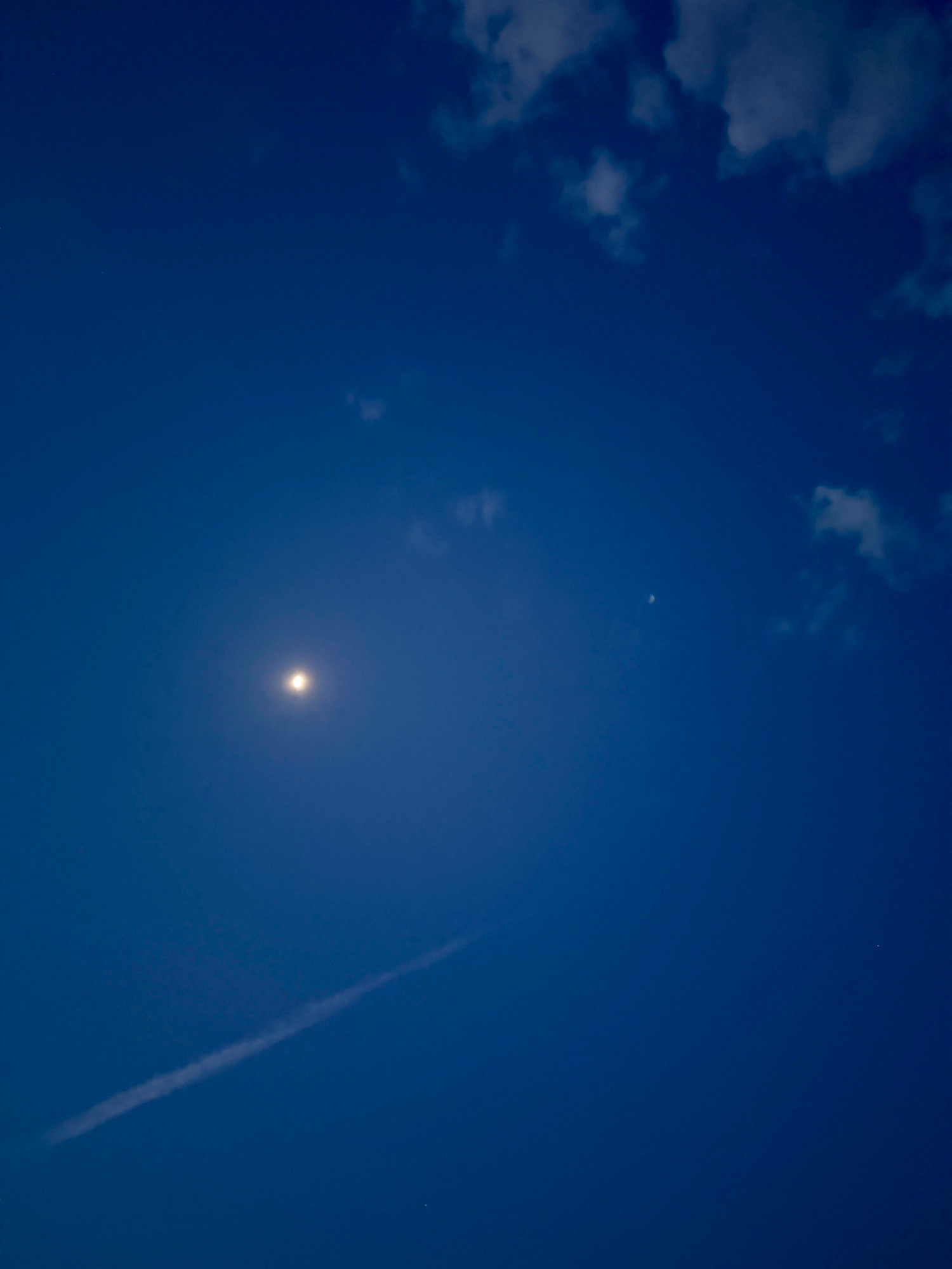 Früher Morgenhimmel mit Mond und ein paar Wolken 