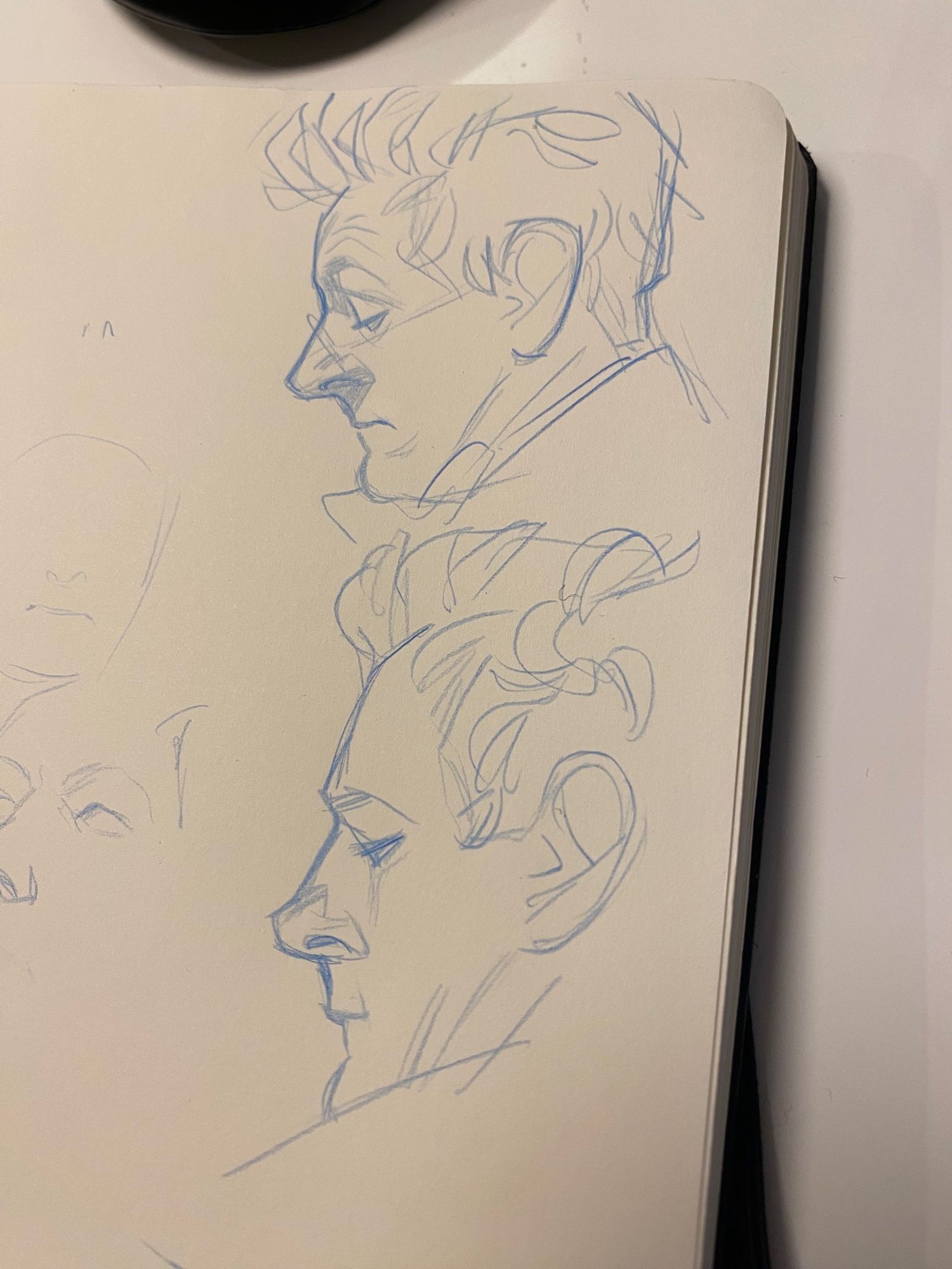 two blue pencil sketches of Michael Sheen in profile as Aziraphale in Good Omens