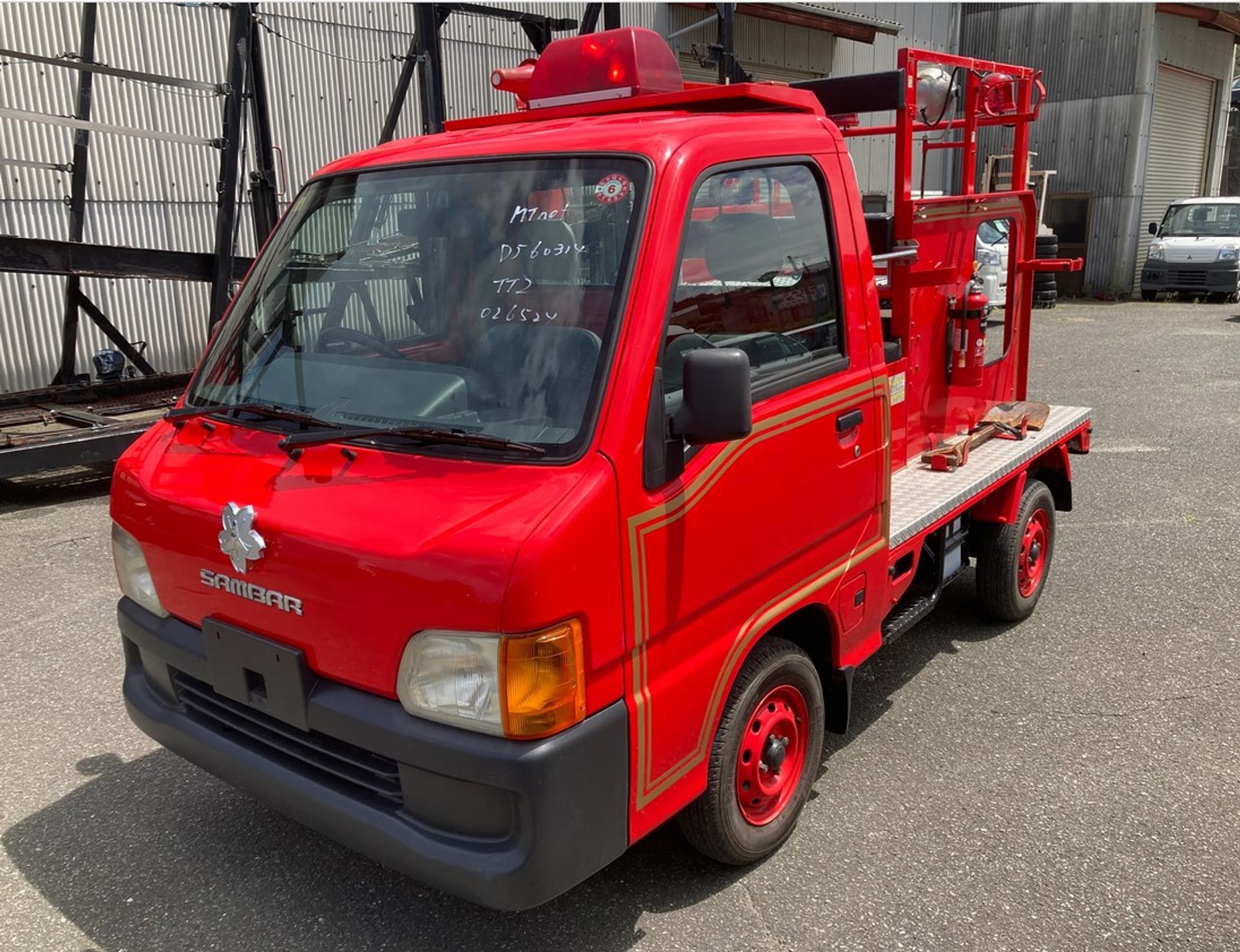 tiny red japanese firetruck, it looks like a toy, the fire truck part is only as big as the cab, which is about the size of the front half of a smartcar