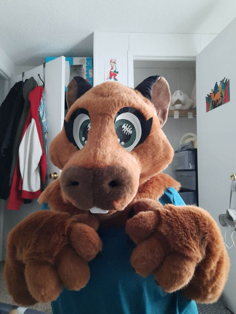 Photo of a toony capybara costume. Both hands are facing down.