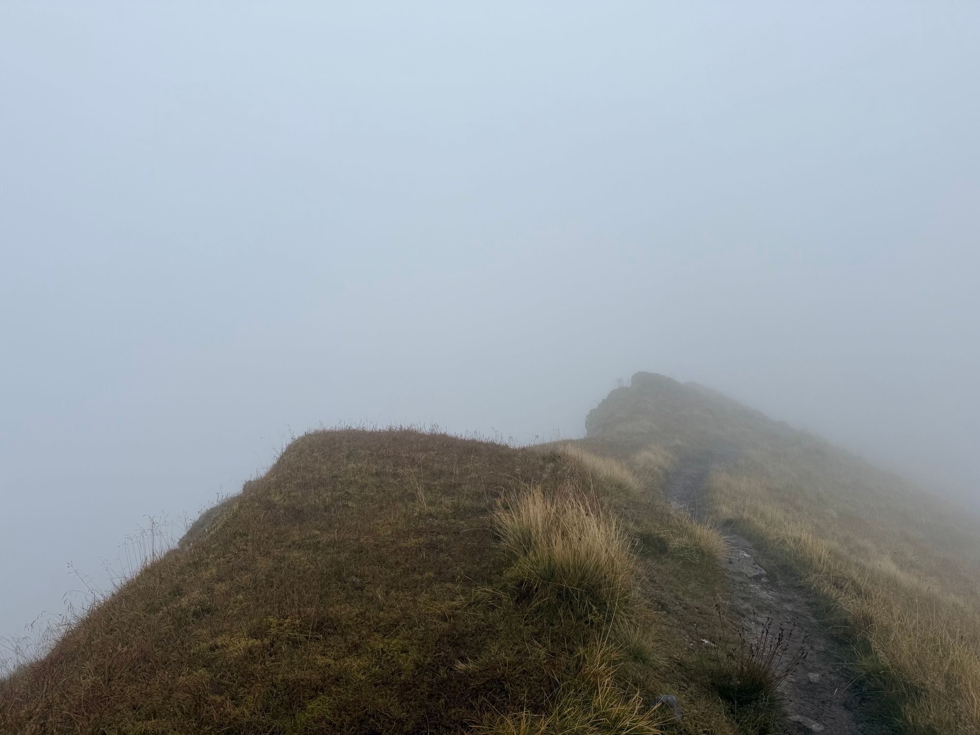 A narrow path on a narrow ridge in deep cloud