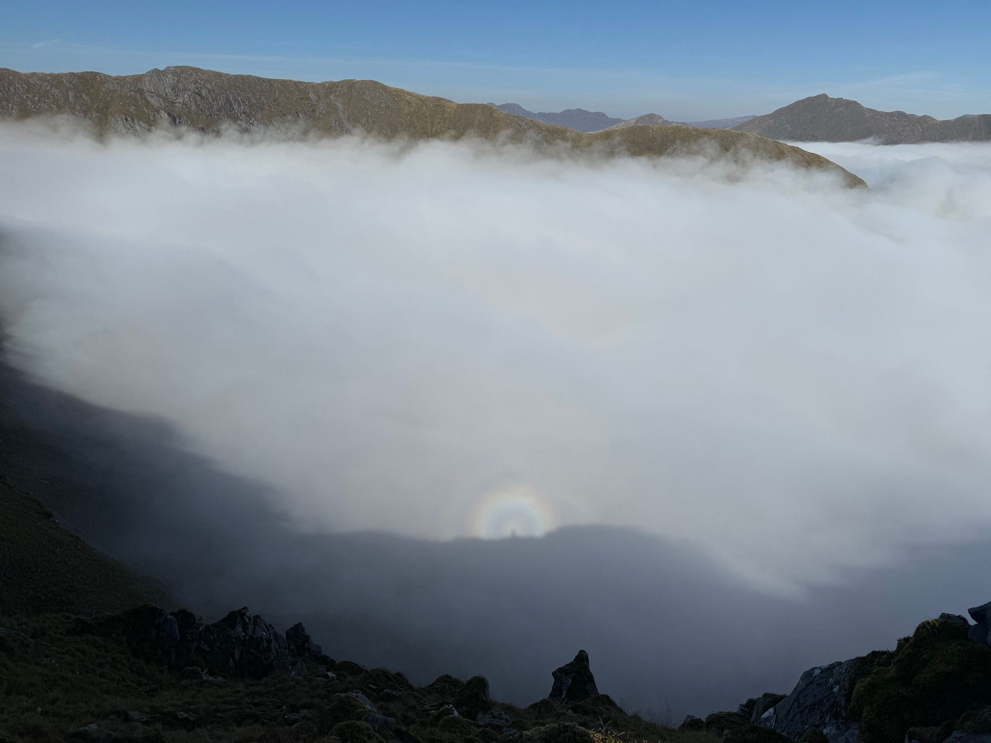 Looking down to the clouds below with a rainbow haloed shadow - a Brocken Spectre