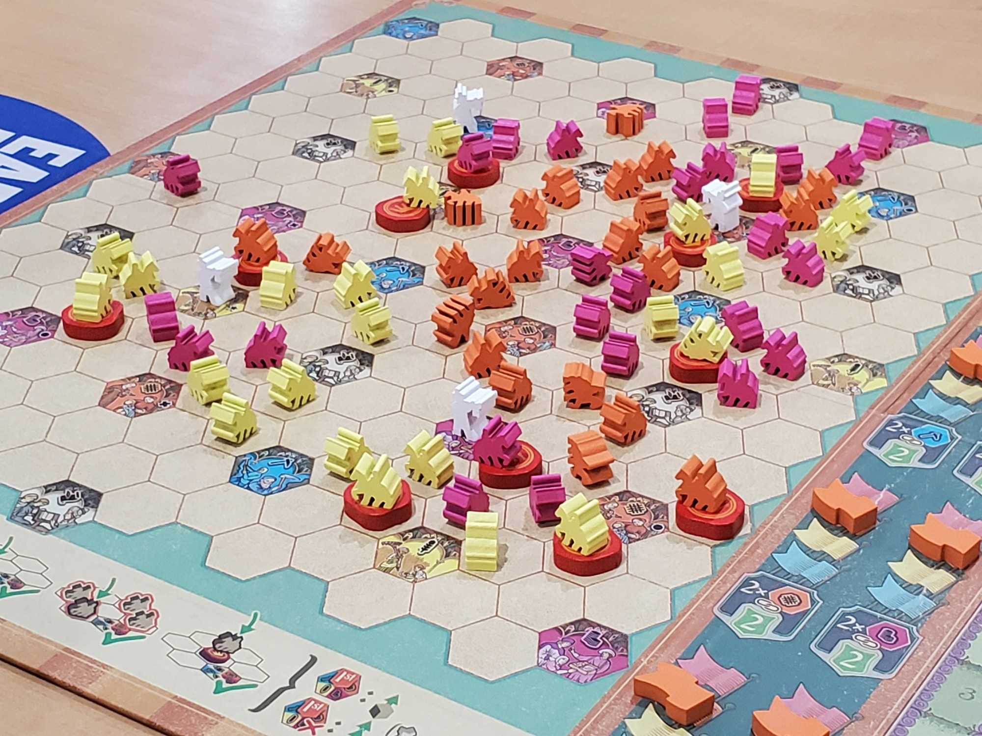 A hex board filled with orange, yellow, and pink knights.