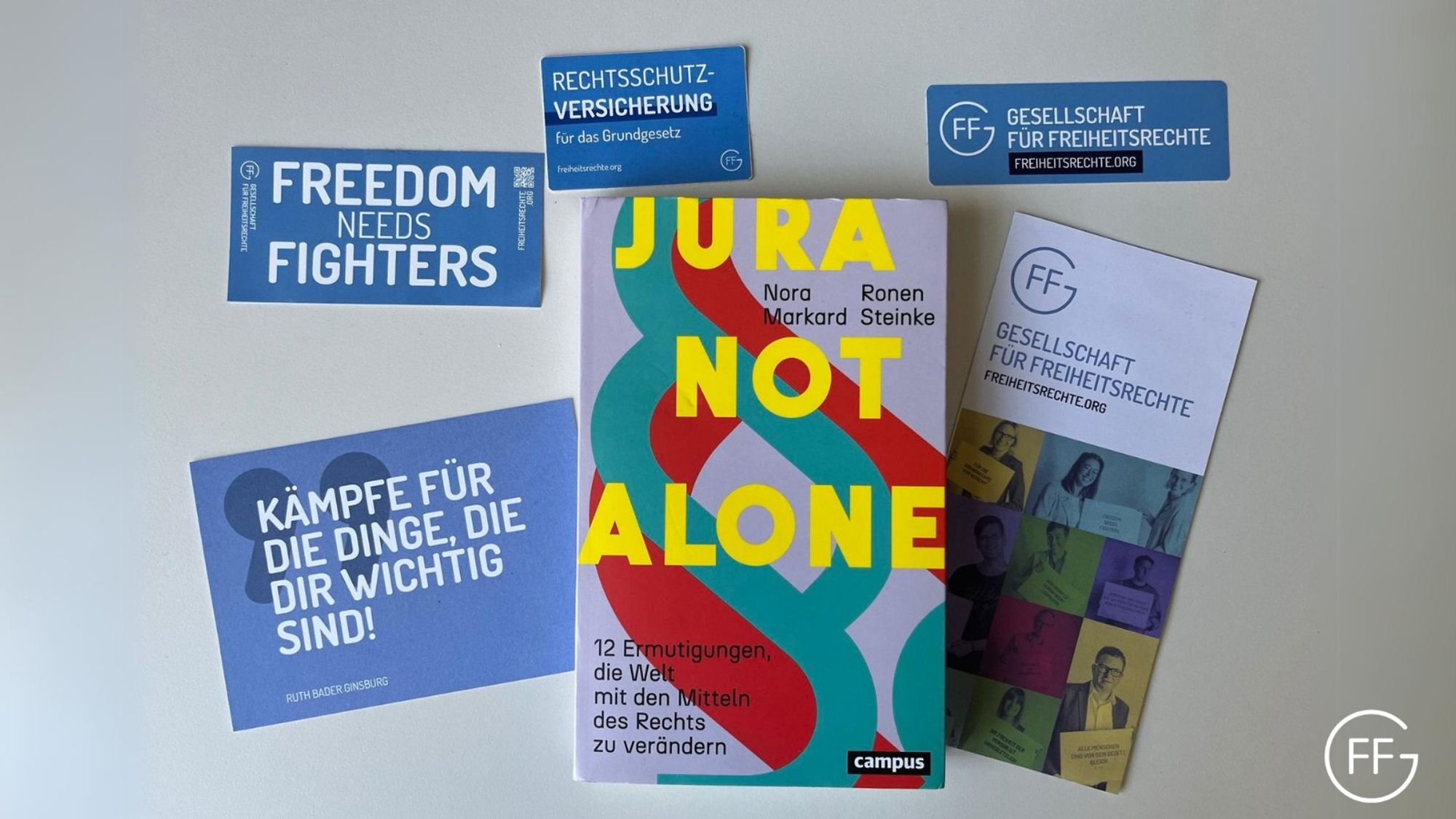 Das Buch "Jura not alone" und Sticker, Postkarten und Flyer der GFF.