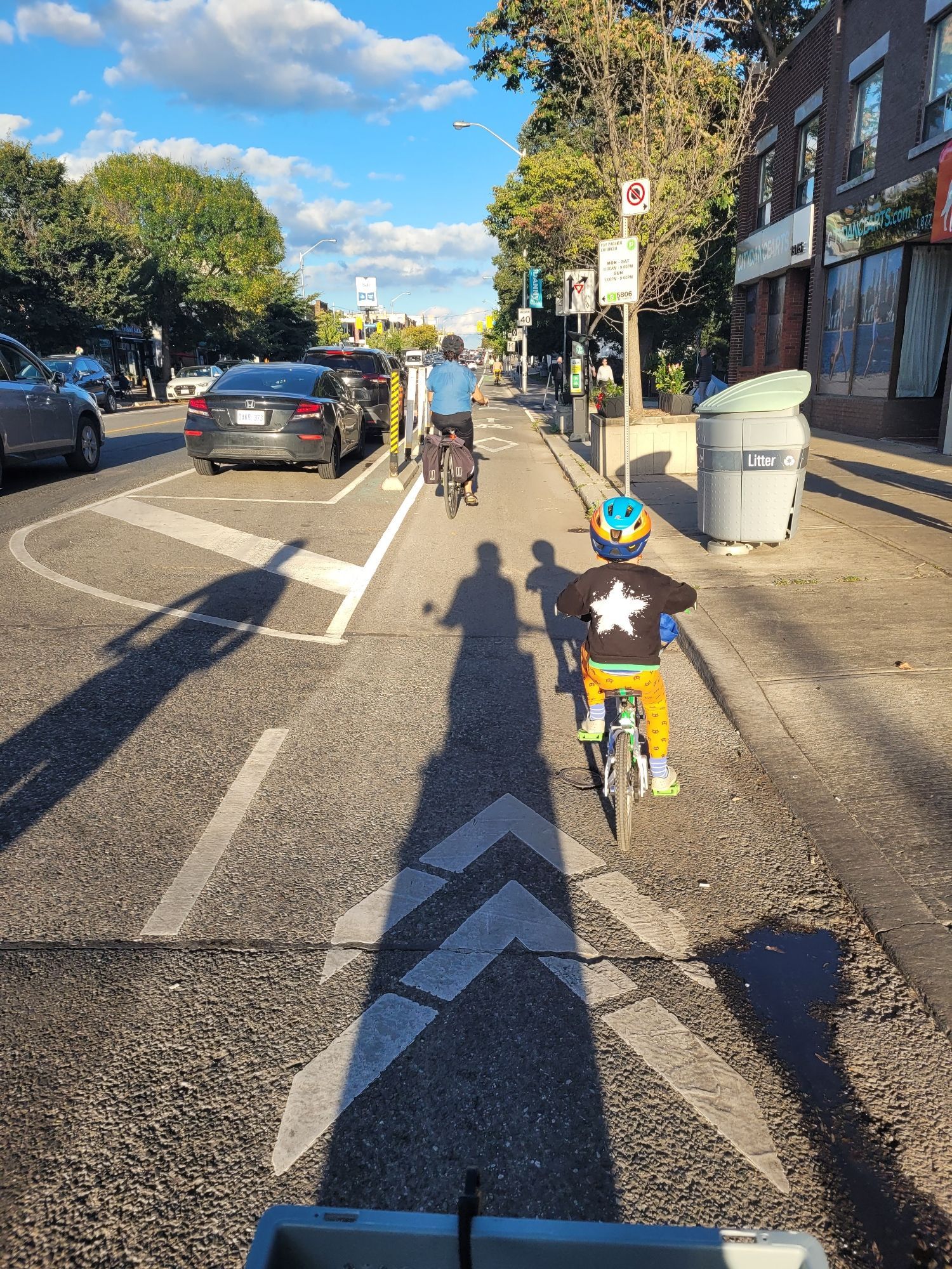 A child rides a small bike in a protected bike lane in Toronto