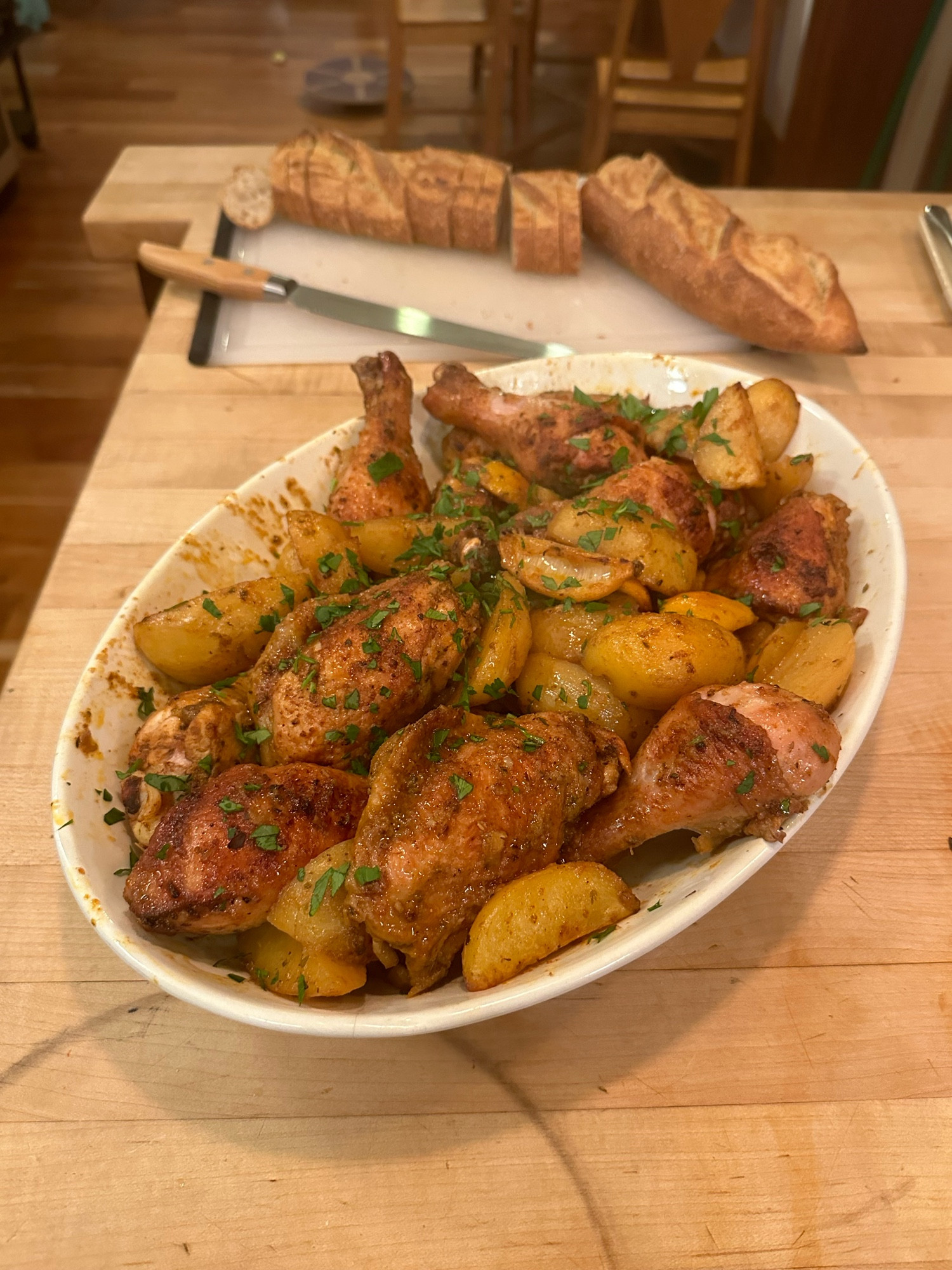 A platter of golden brown chicken and potatoes with a baguette behind. 

- toss chicken and cut up potatoes with a lot of paprika and garlic powder and oregano and pepper and salt, plus olive oil
- roast in 400f oven for half an hour 
- mix the juice of ~1 lemon, 4 grated garlic cloves, and .25 c chicken broth per every 1 lb of chicken, plus a little salt. 
- remove the chicken and potatoes and pour over sauce, stirring it up well
- back in the oven for 15 minutes 
- take out the chicken pieces to rest for 15 minutes and keep those potatoes in there so they get plenty sauce
- if the chicken isn’t nicely toasty feel free to chuck it back in the pan at the end and hit it with the broiler for a minute or two
- save every bit of sauce and pour it on everything