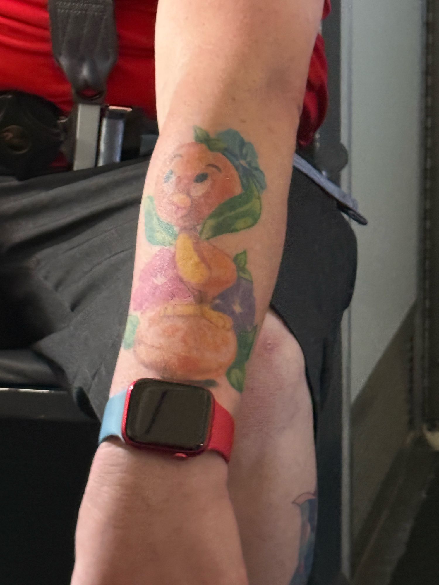 arm tattoo of the little orange bird