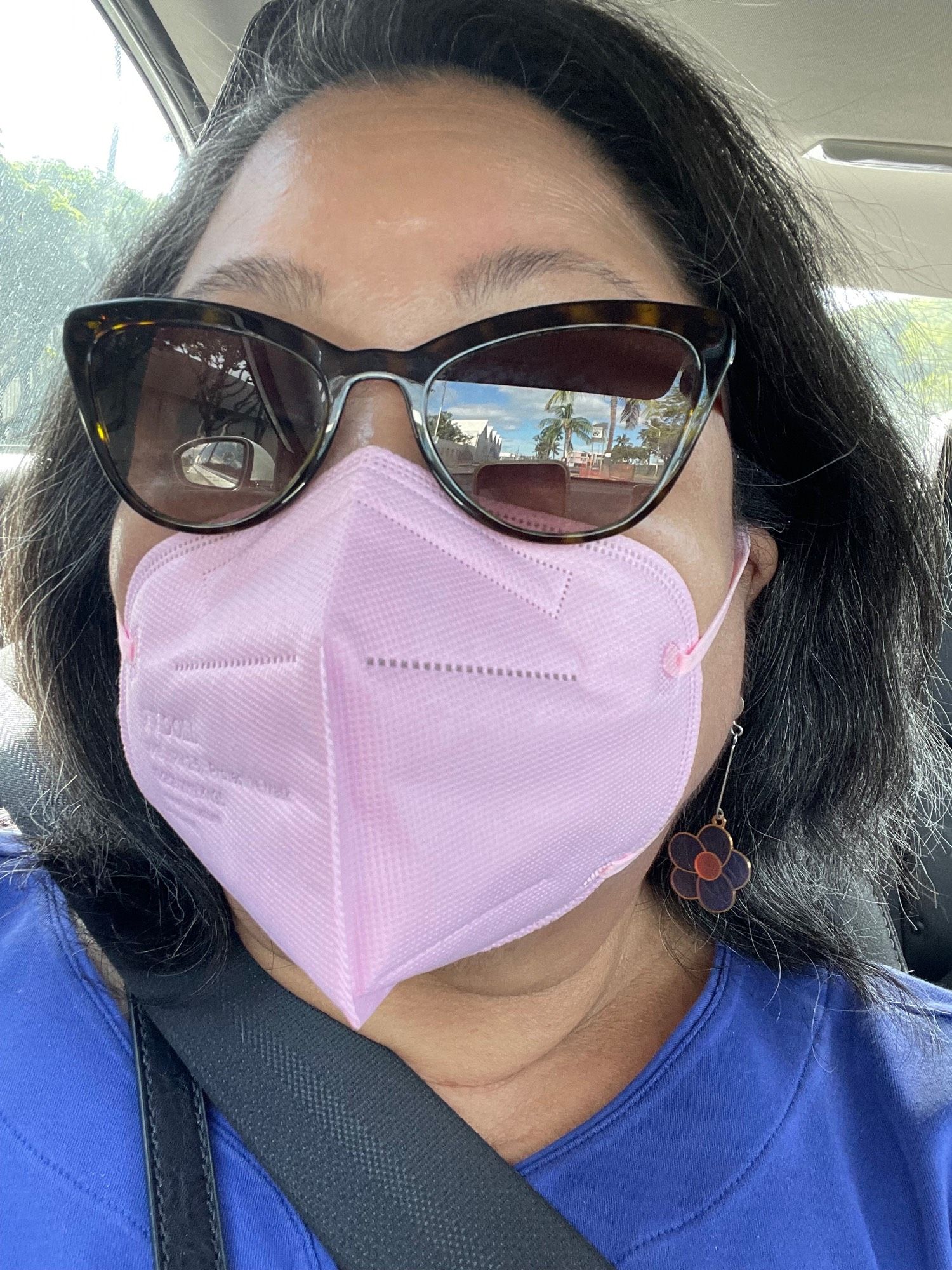 Woman wearing face mask and sunglasses.