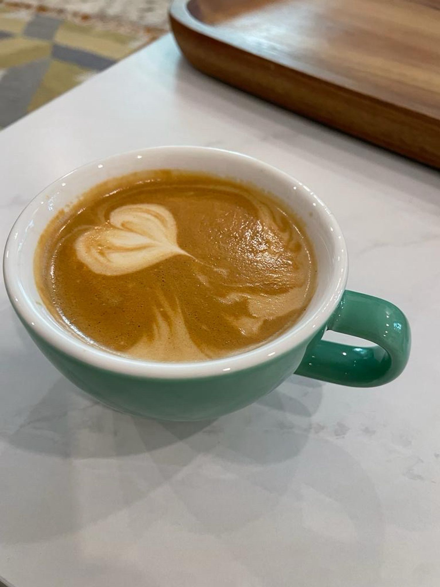 A coffee with some decent, though off-center, latte art.