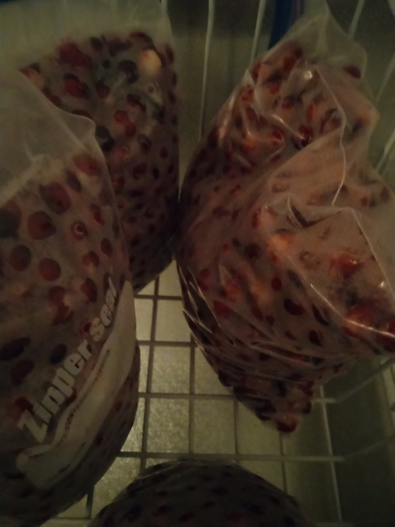 5 large freezer bags full of big red cranberries. Being frozen after cleaning for later use throughout the year. The freezer basket shows under the bags