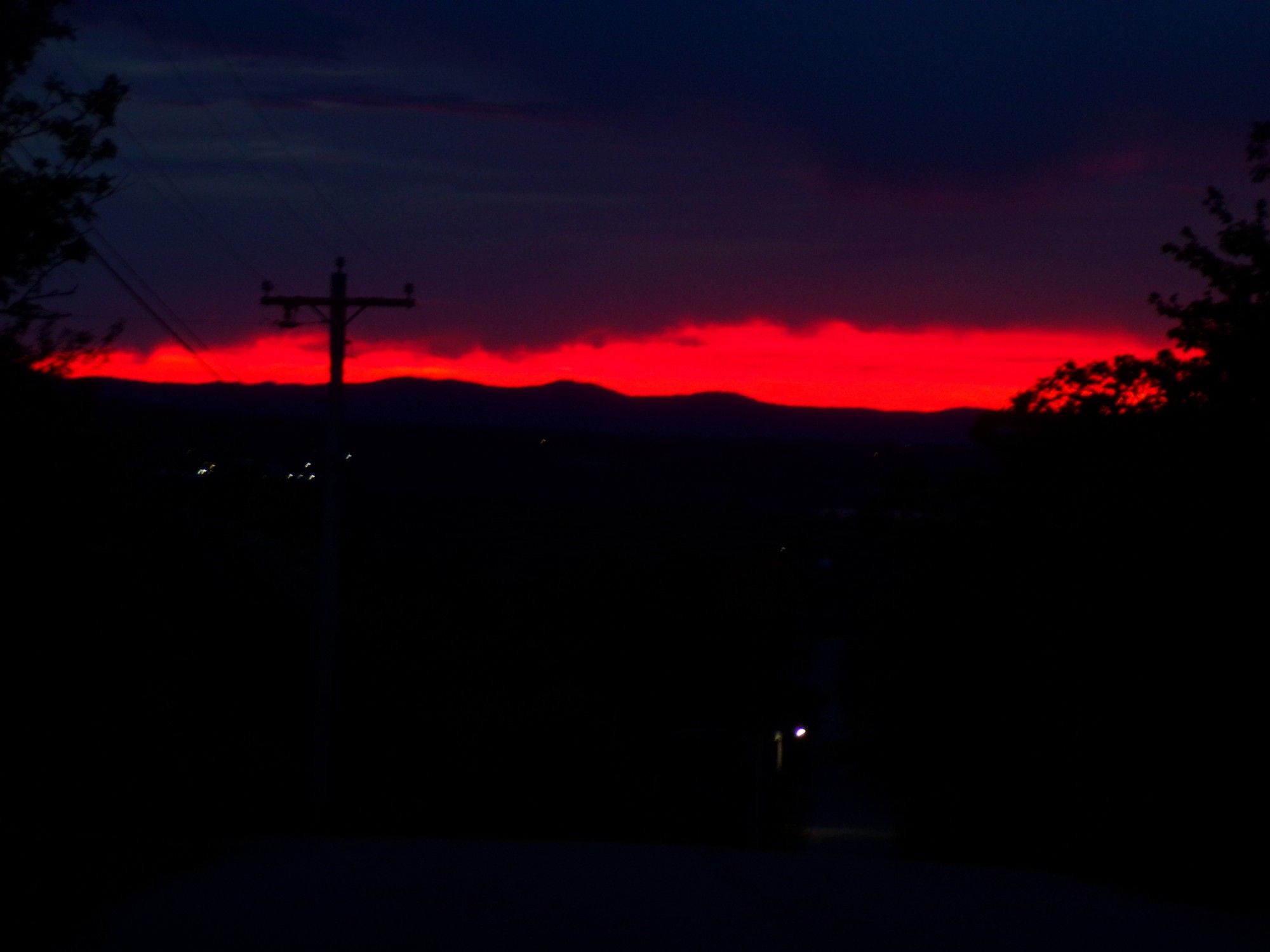 A black sky, split by bright red of the approaching dawn