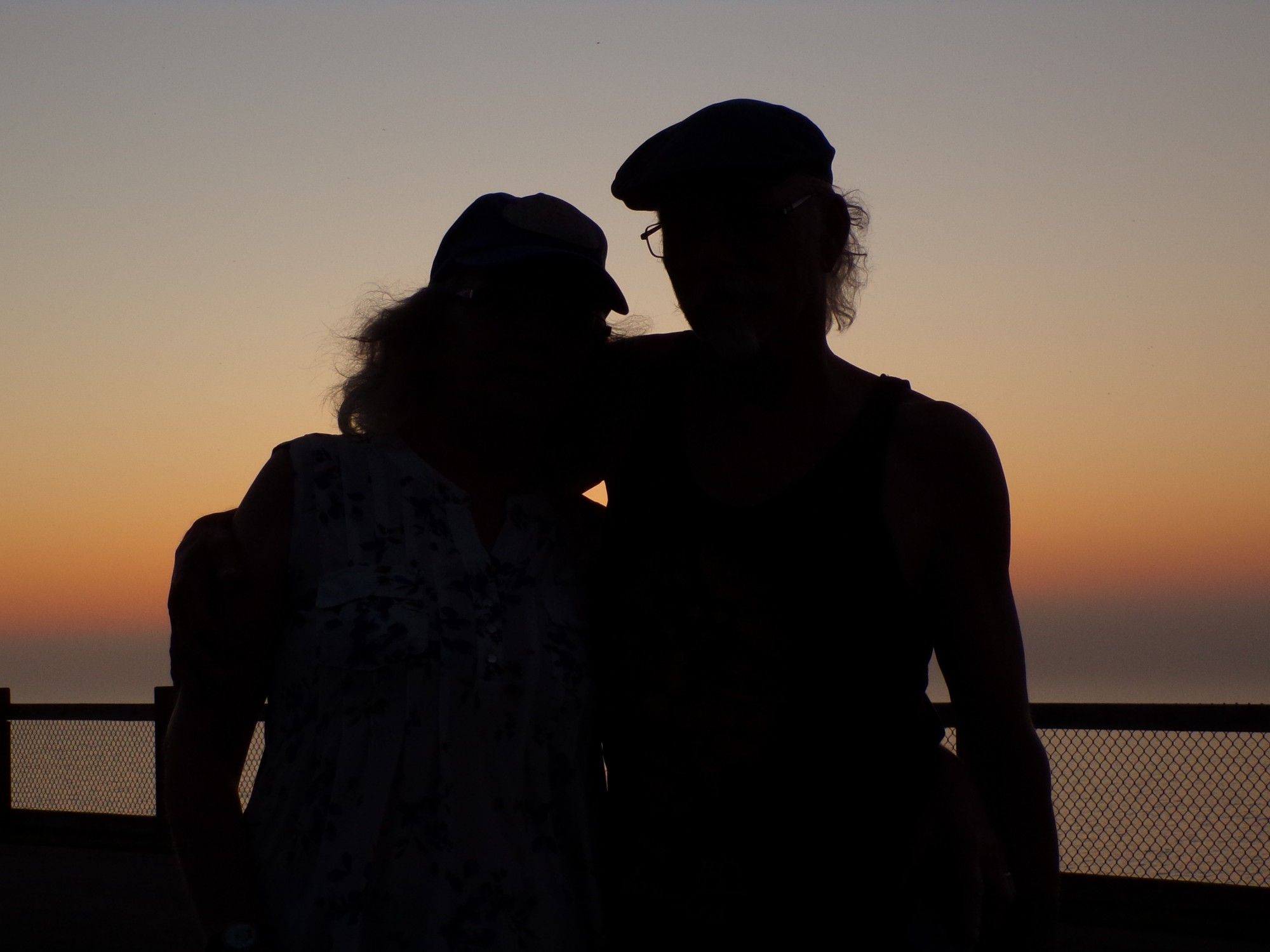 A silhouette of a couple against the setting sun over Lake Erie.