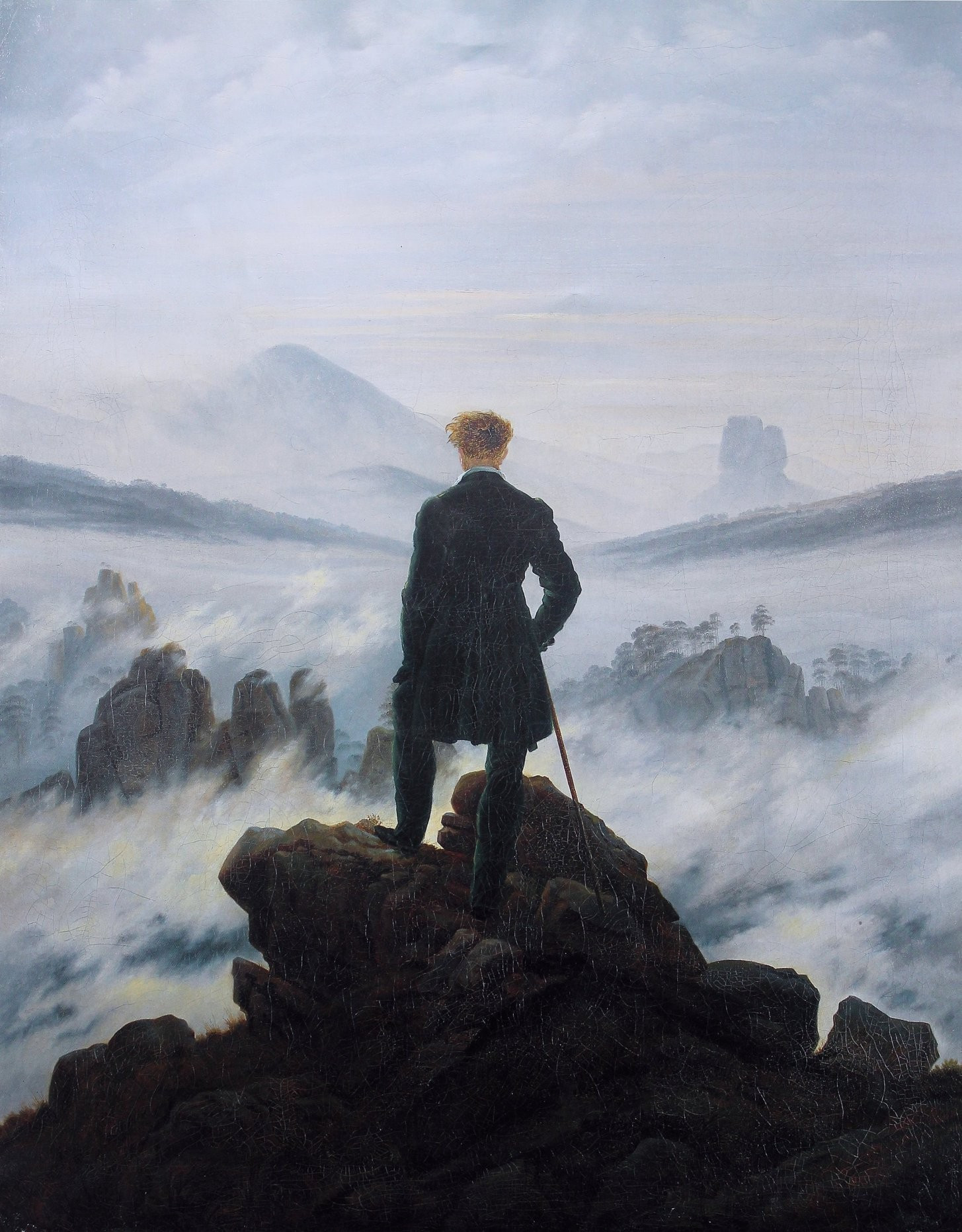 In the painting a youngish man with a walking stick stands on an outcropping of rock, looking down on a valley obscured by fog.