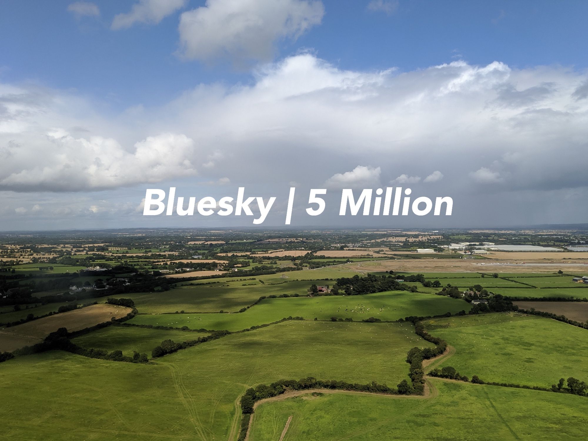 A photo of Ireland, with “Bluesky: 5 Million” floating on the horizon