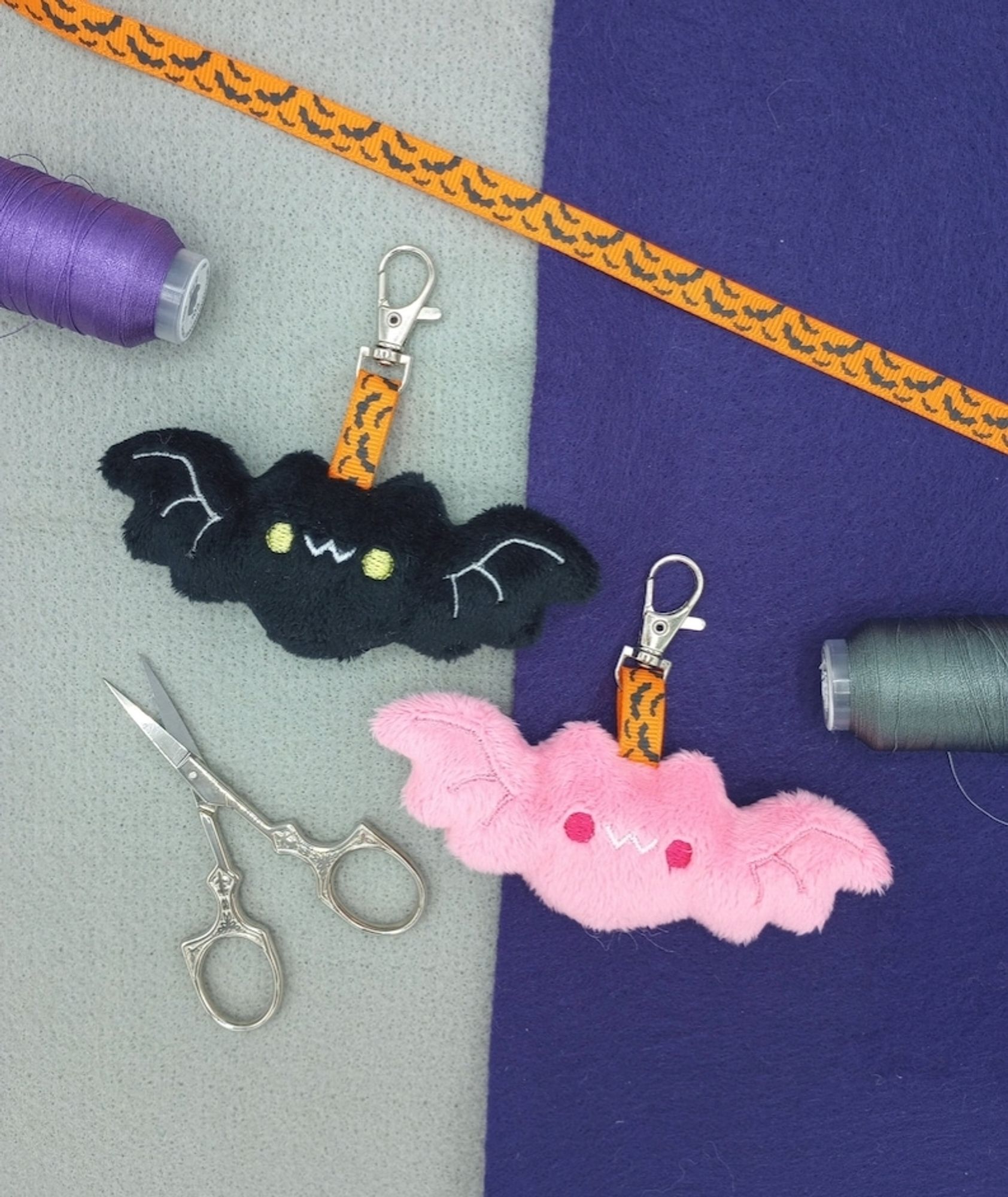 Two handmade kawaii bat plushie keychains.