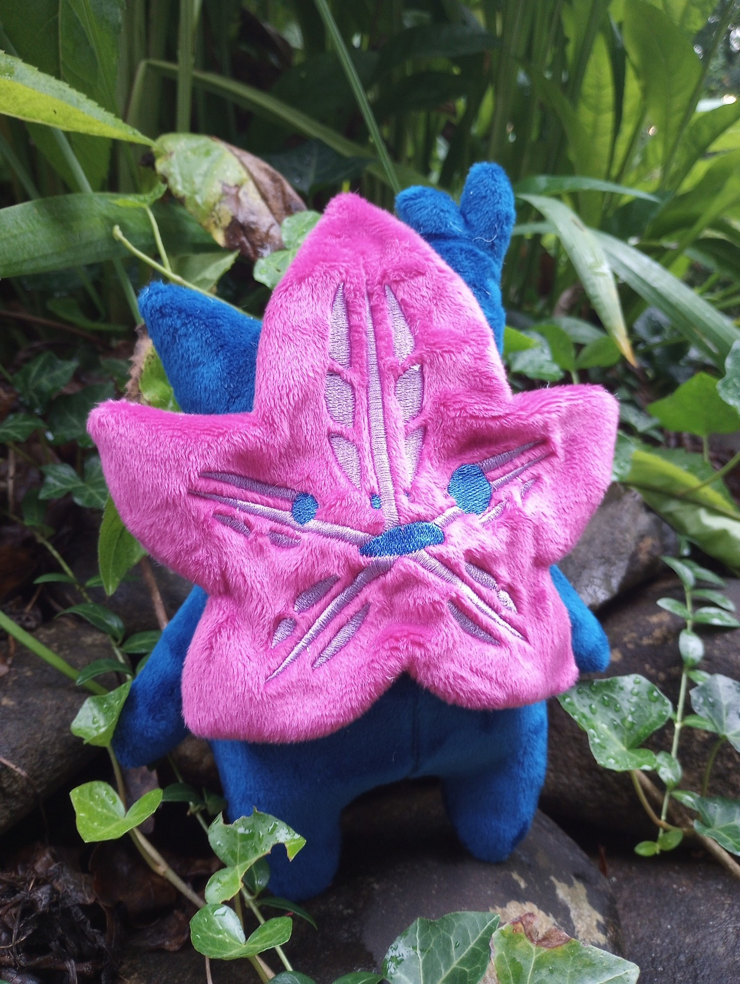 A handmade Bisexual Pride Korok plushie from the Legend of Zelda.