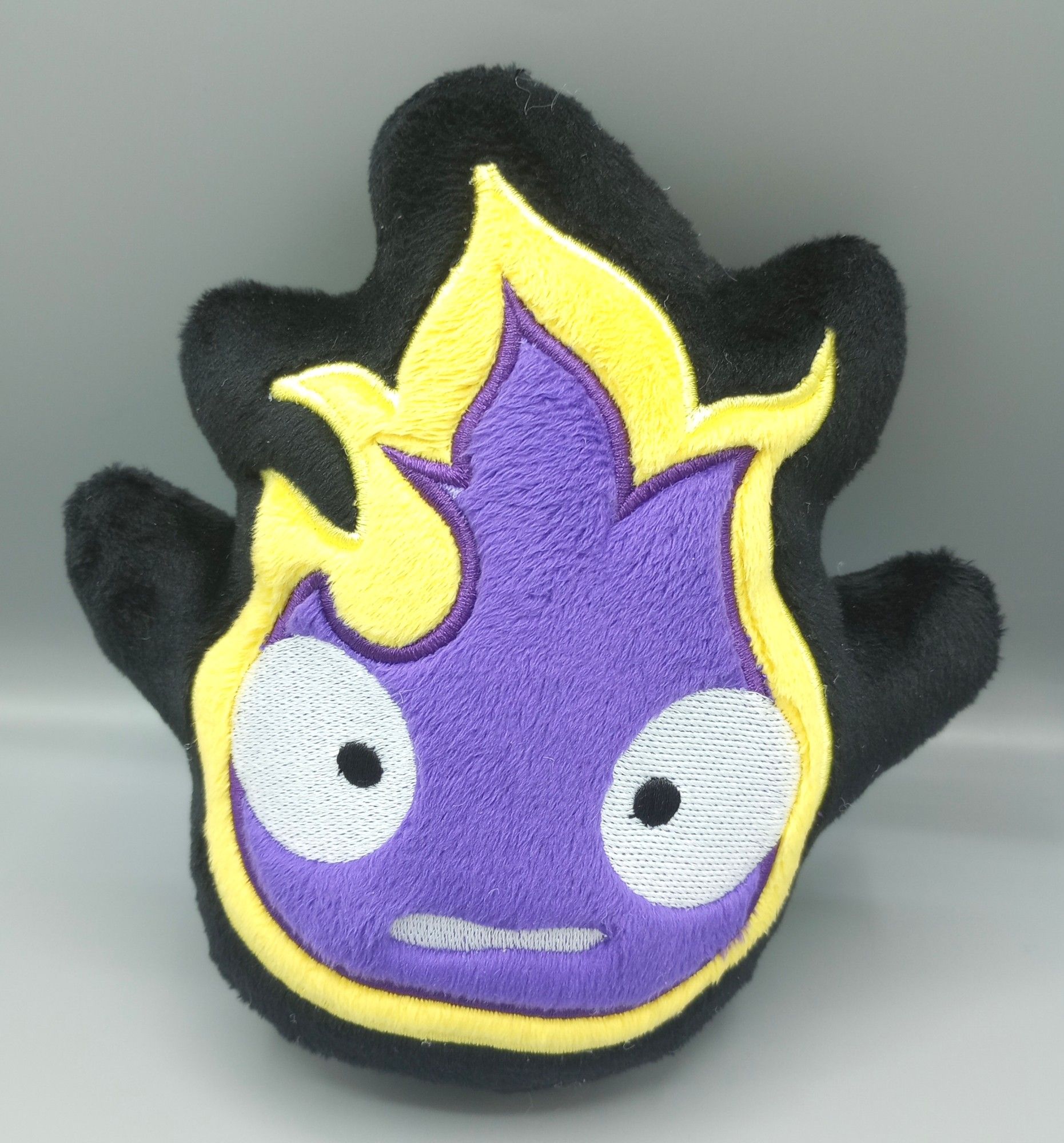 A handmade Non-Binary Pride Calcifer plushie from the Studio Ghibli movie Howl's Moving Castle.