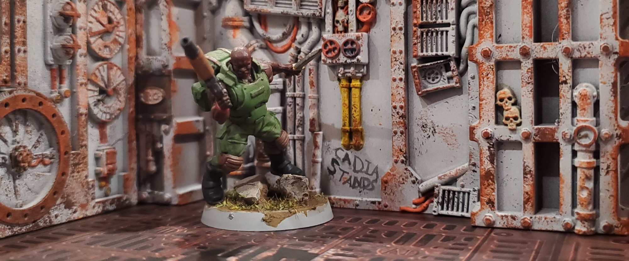 A photo of a reptilian overlords "spacenam" 28mm mini painted in front of a scifi wall