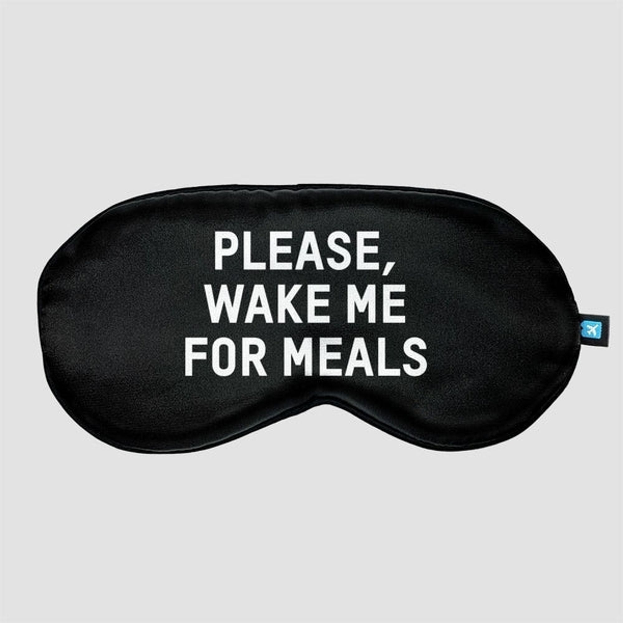 black sleepmask saying "please wake me for meals"