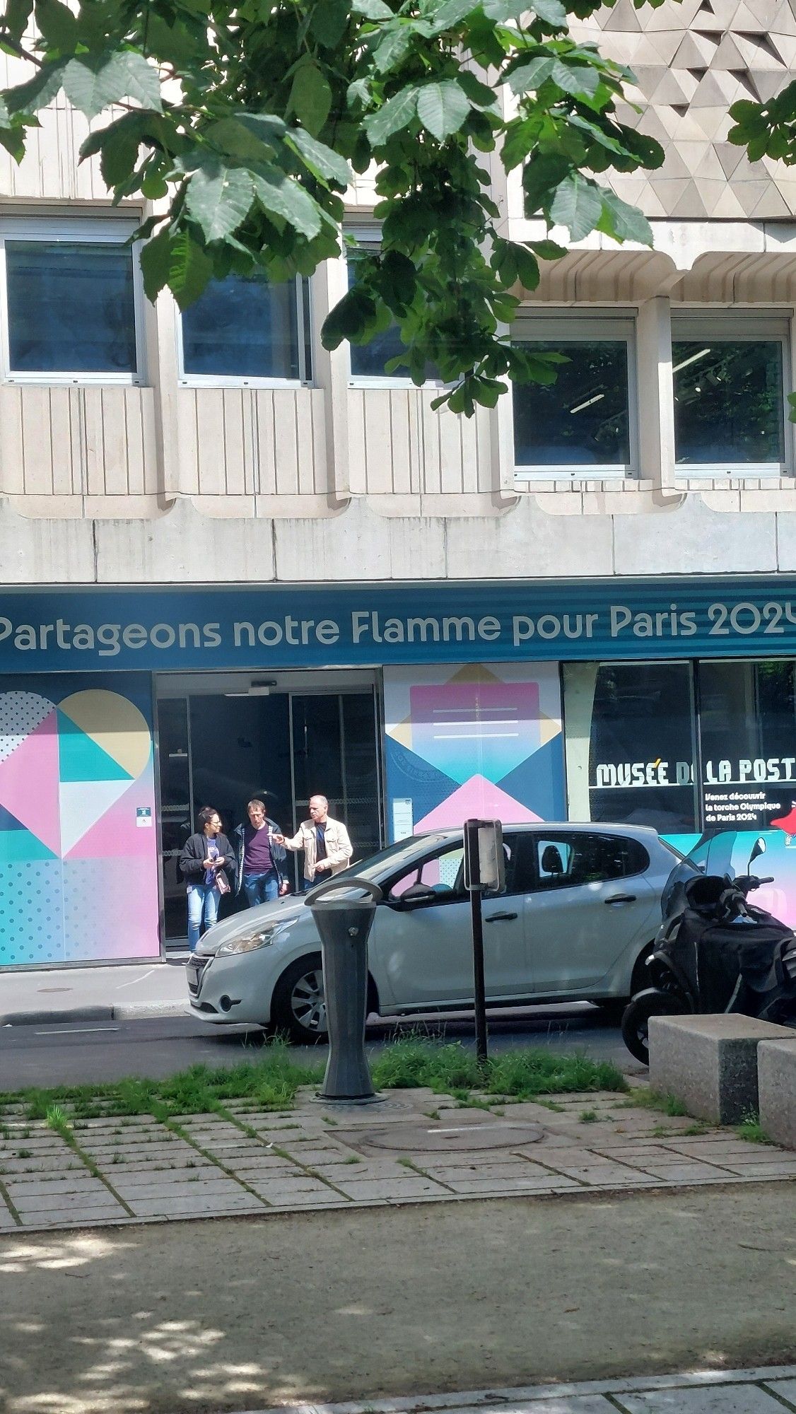 Slogan du musée de la Poste qui dit "Partageons notre flamme pour Paris 2024"