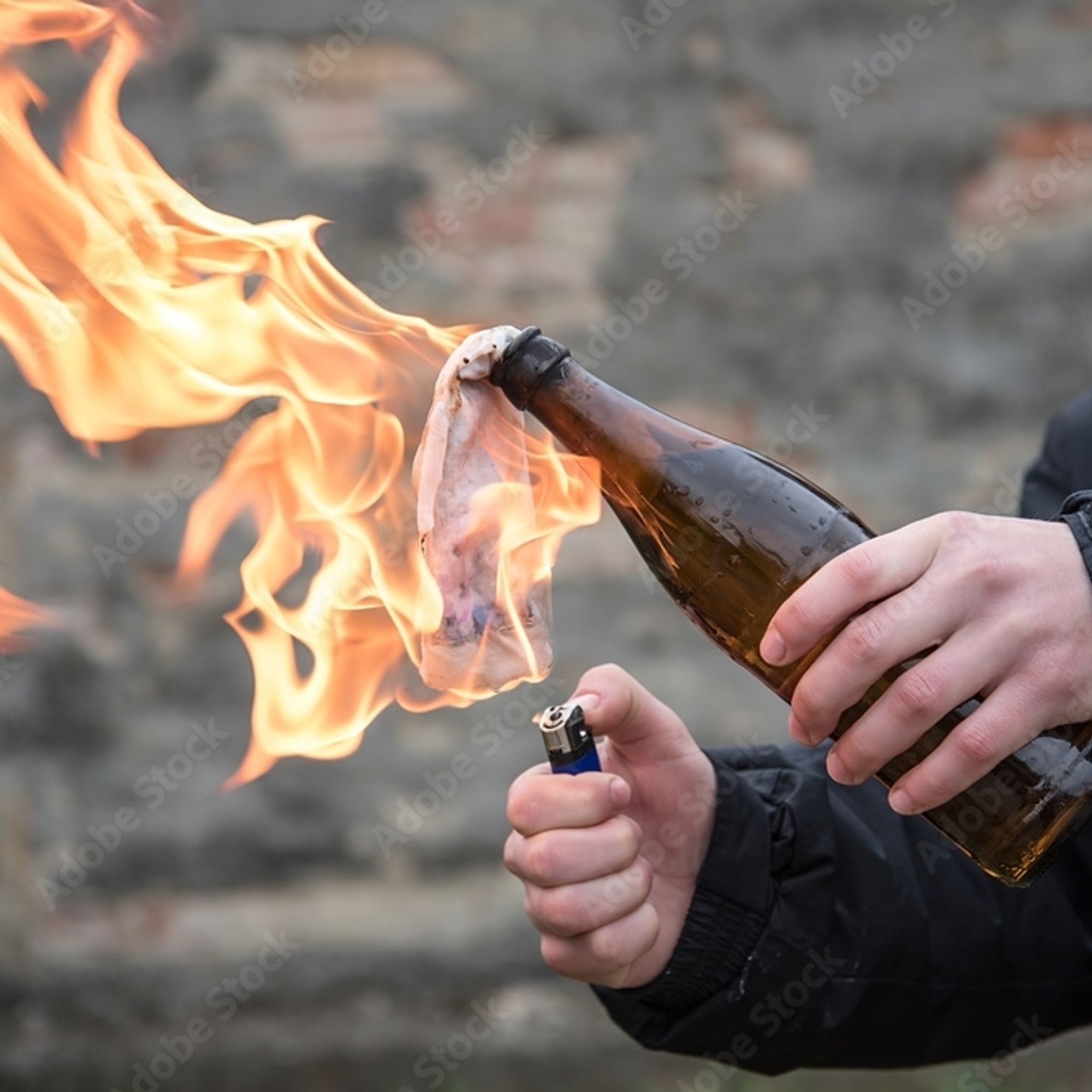 Des mains qui allument un cocktail molotov