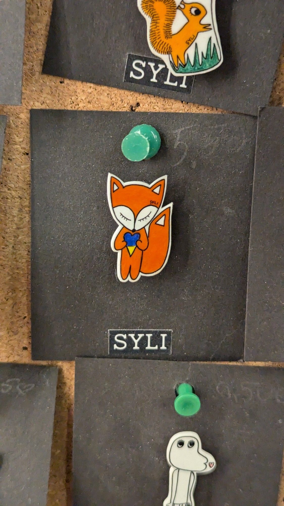 A fox pin holding a blue heart in a shop in Tallinn