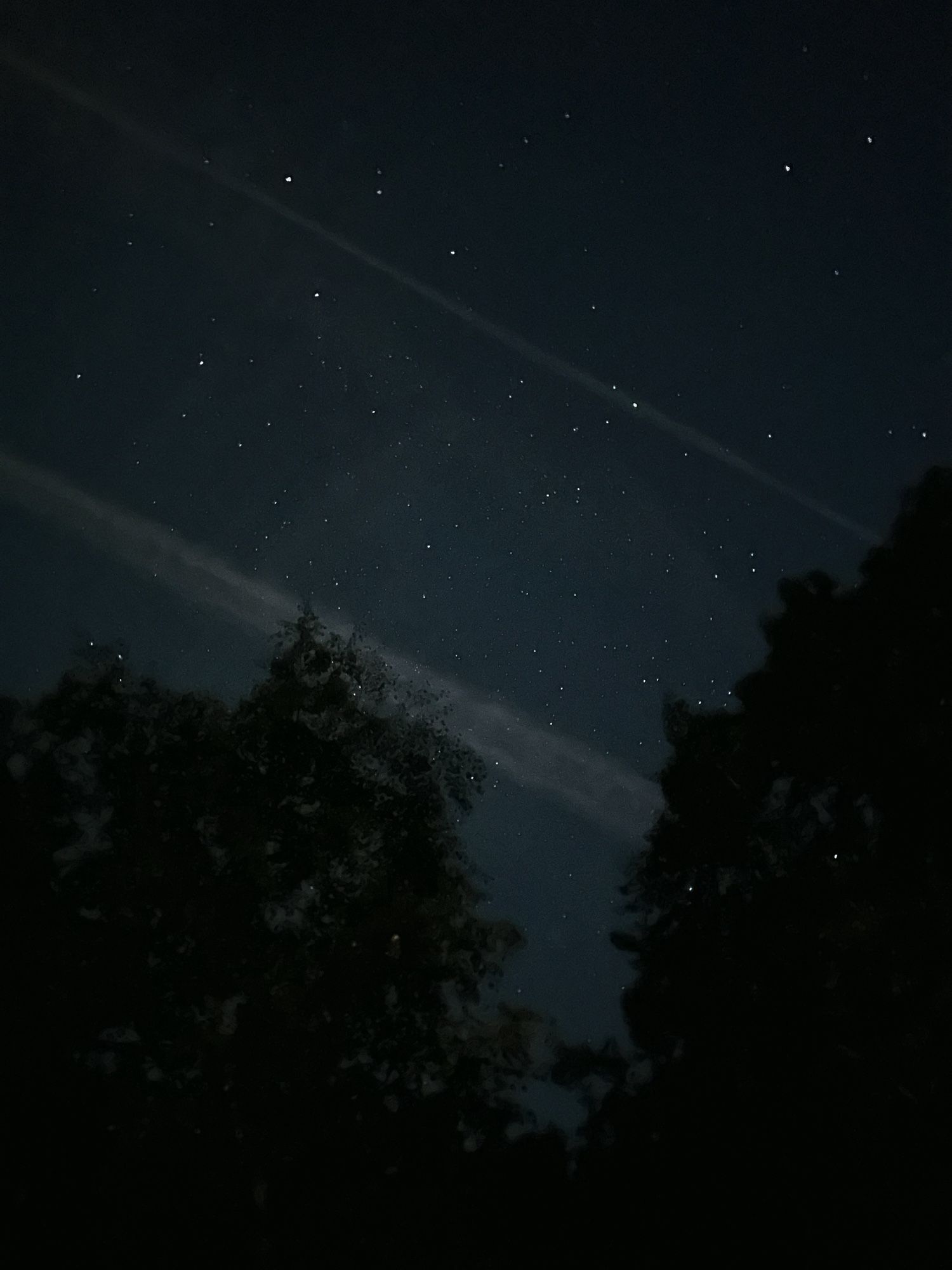 The night sky with jet trails and stars