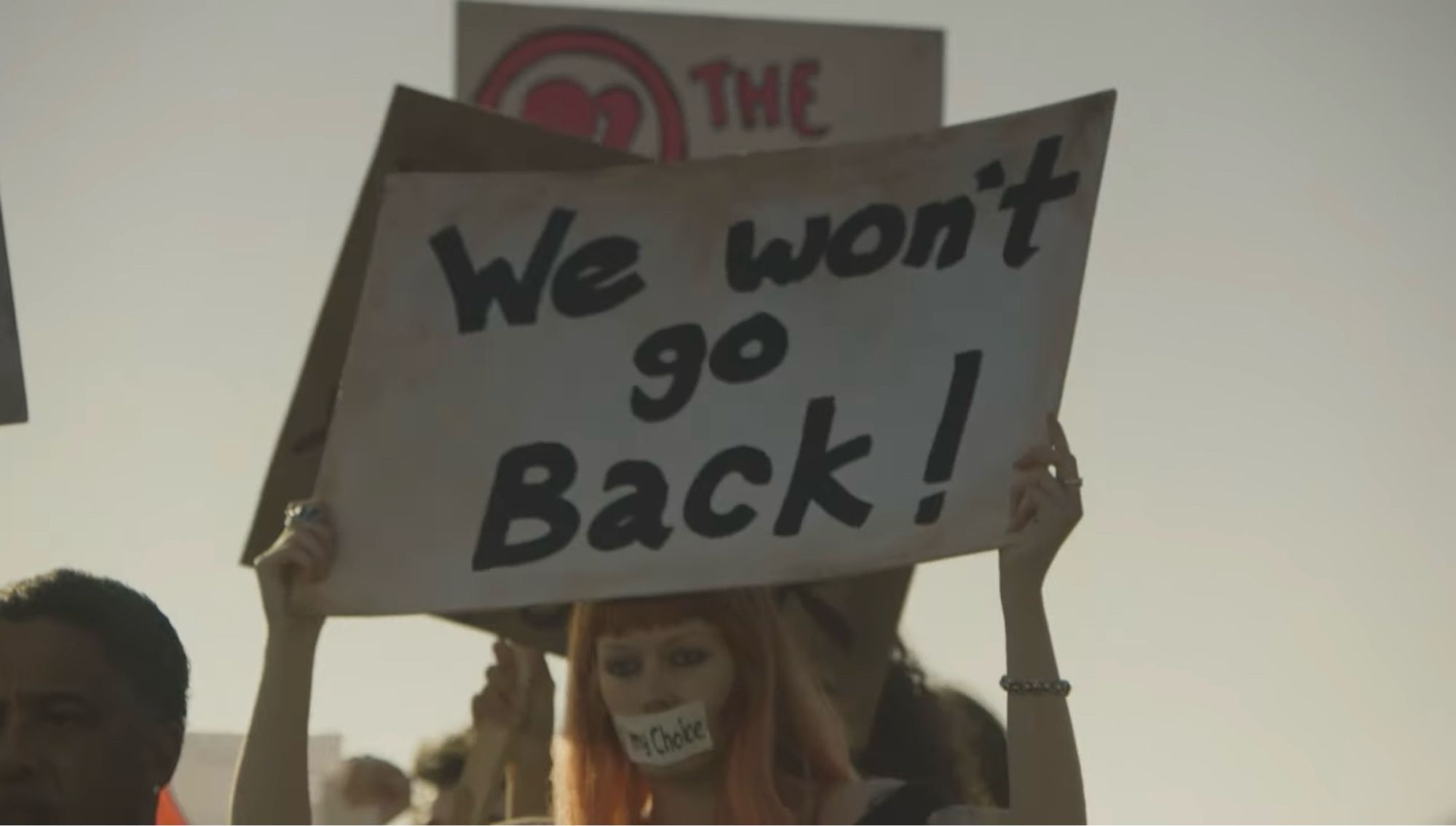 Woman holding we won’t go back sign