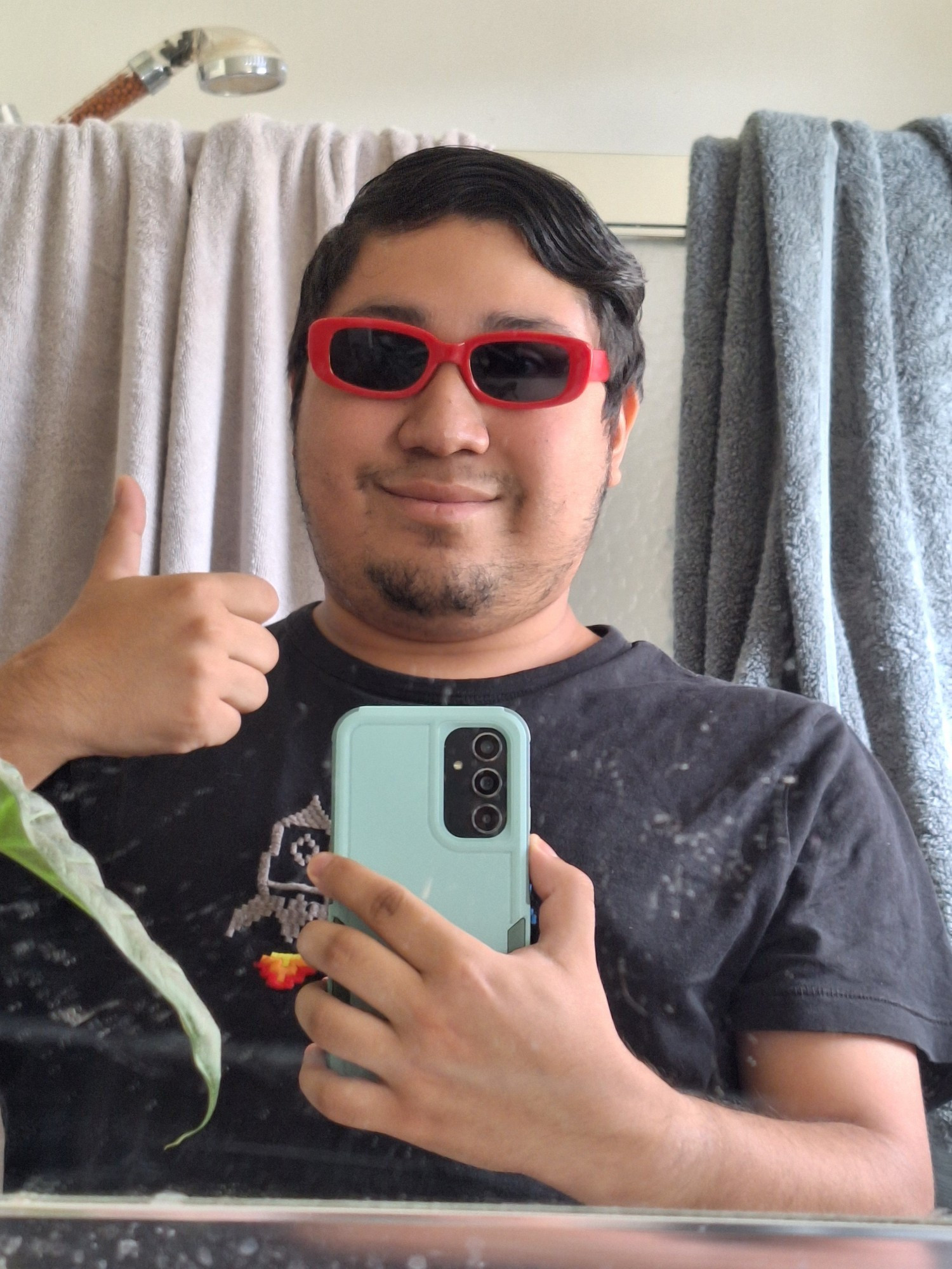 A mirror selfie of Pancake wearing red sunglasses and giving a thumbs up.