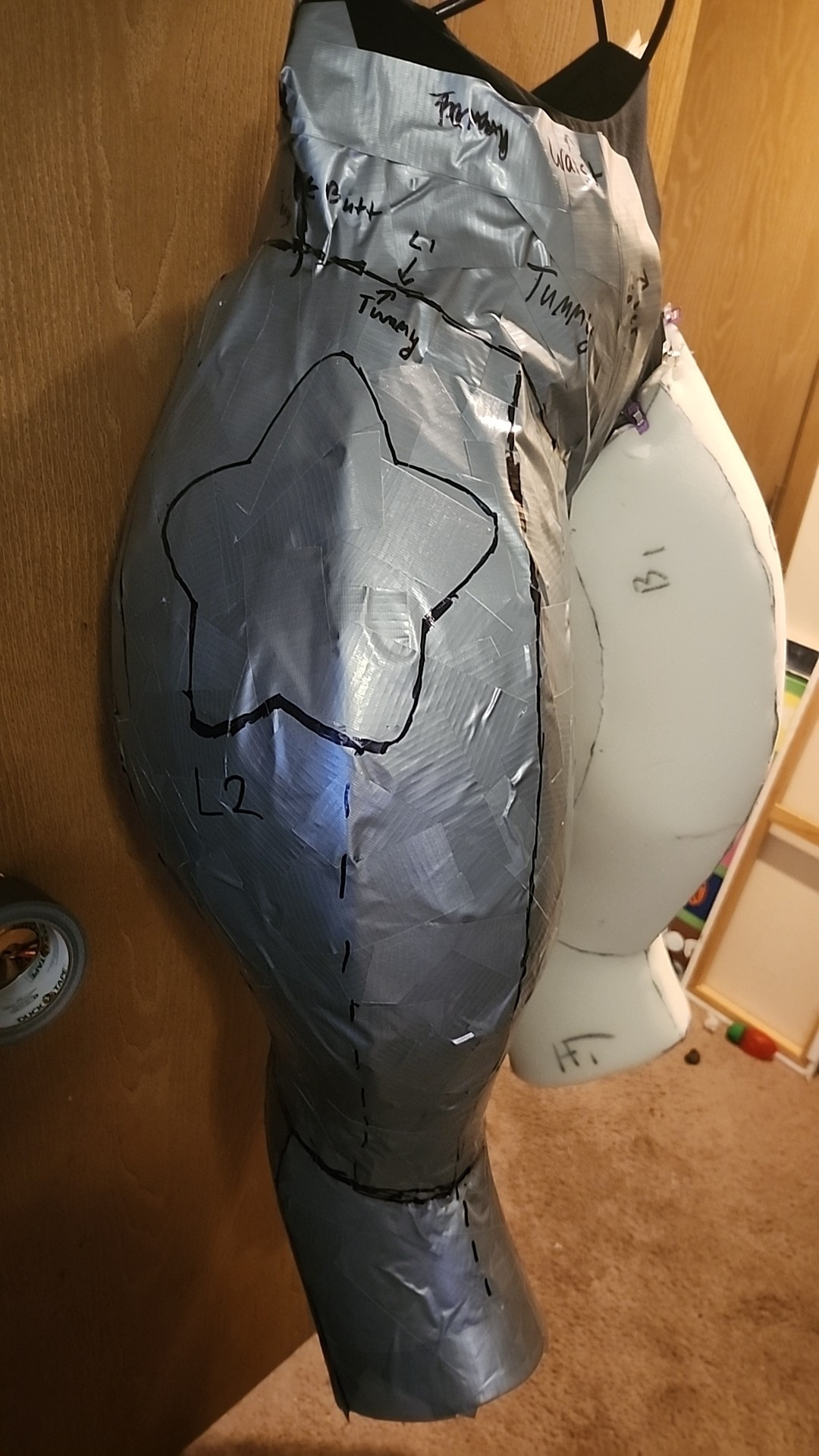 Fursuit legs in a state of mid-completion. There is duct tape on one side of the leg bases.