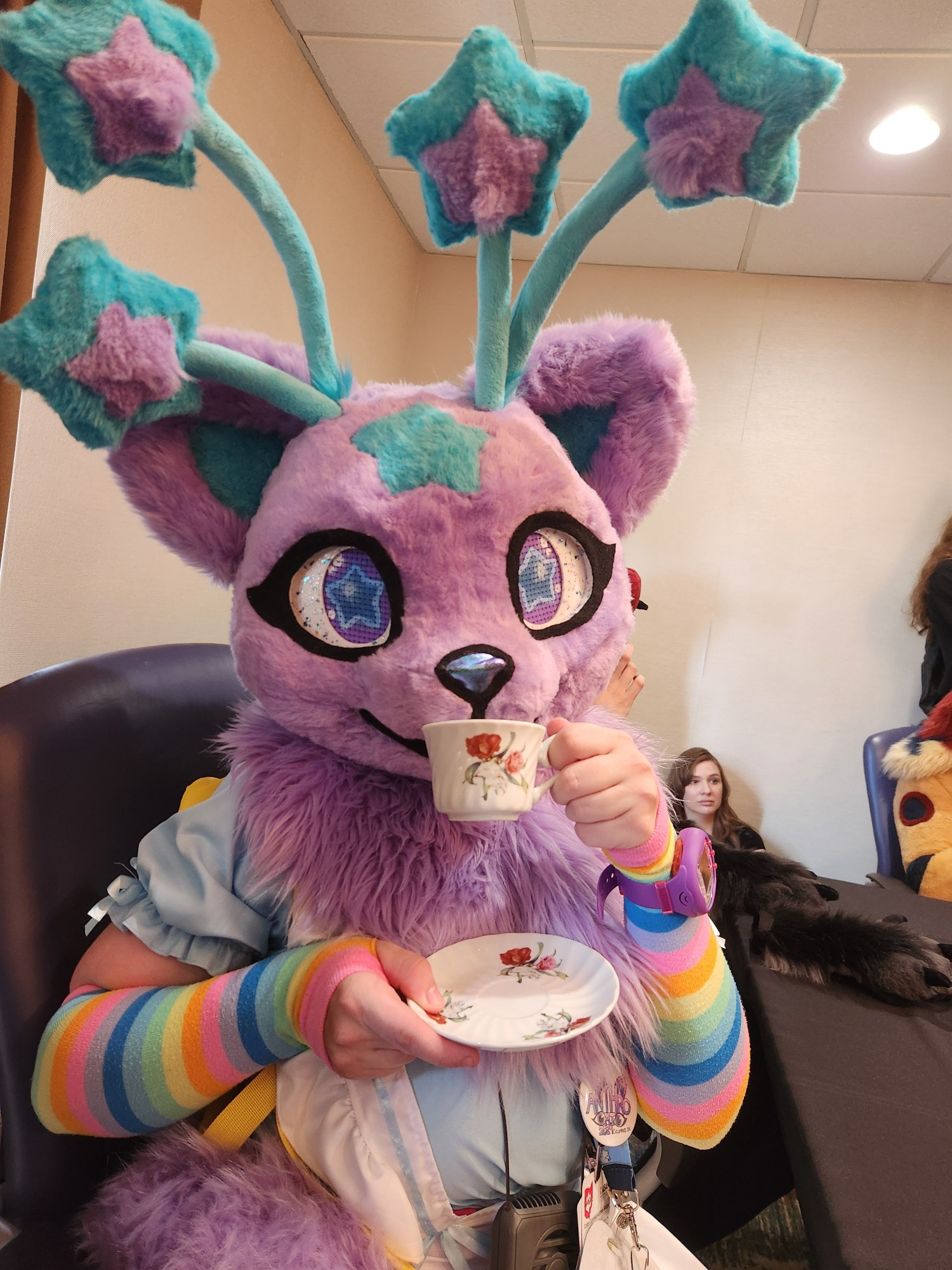 Nova Skystar fursuiter wearing a maid dress and holding a teacup and saucer