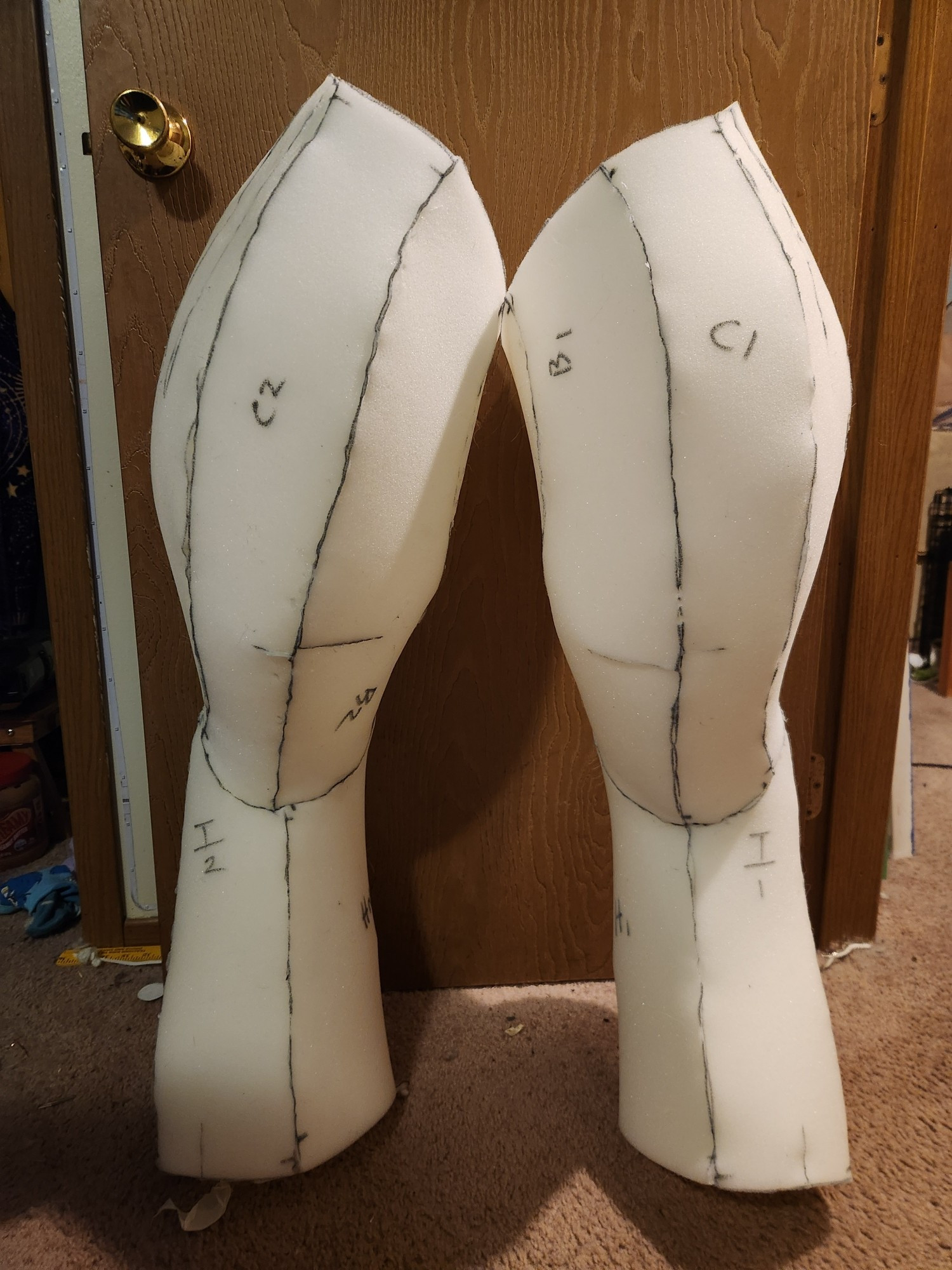 A pair of unfinished digitigrade fursuit legs made out of foam