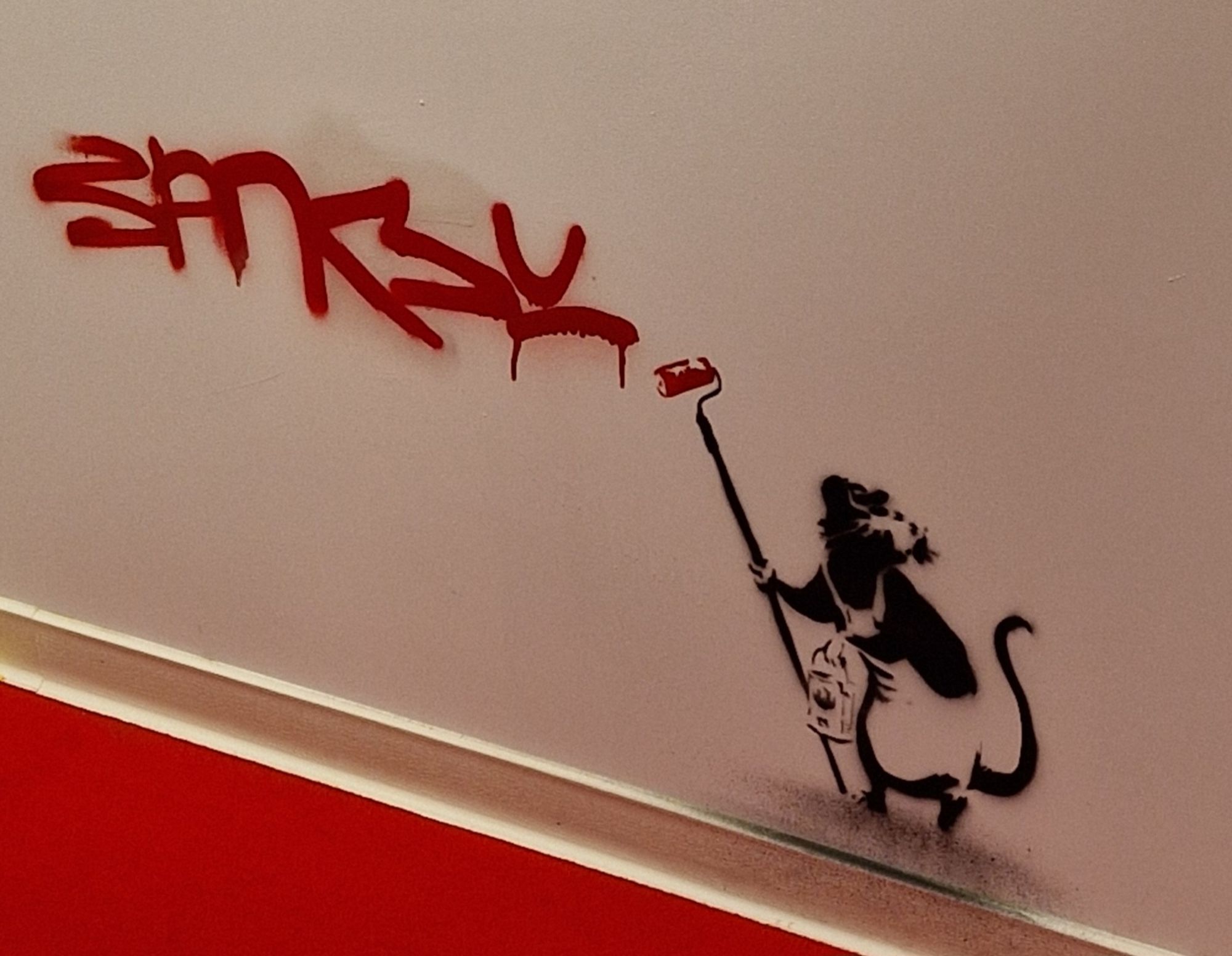 Grafittiratte, die mit Farbrolle Banksy an eine Wand gerollt hat